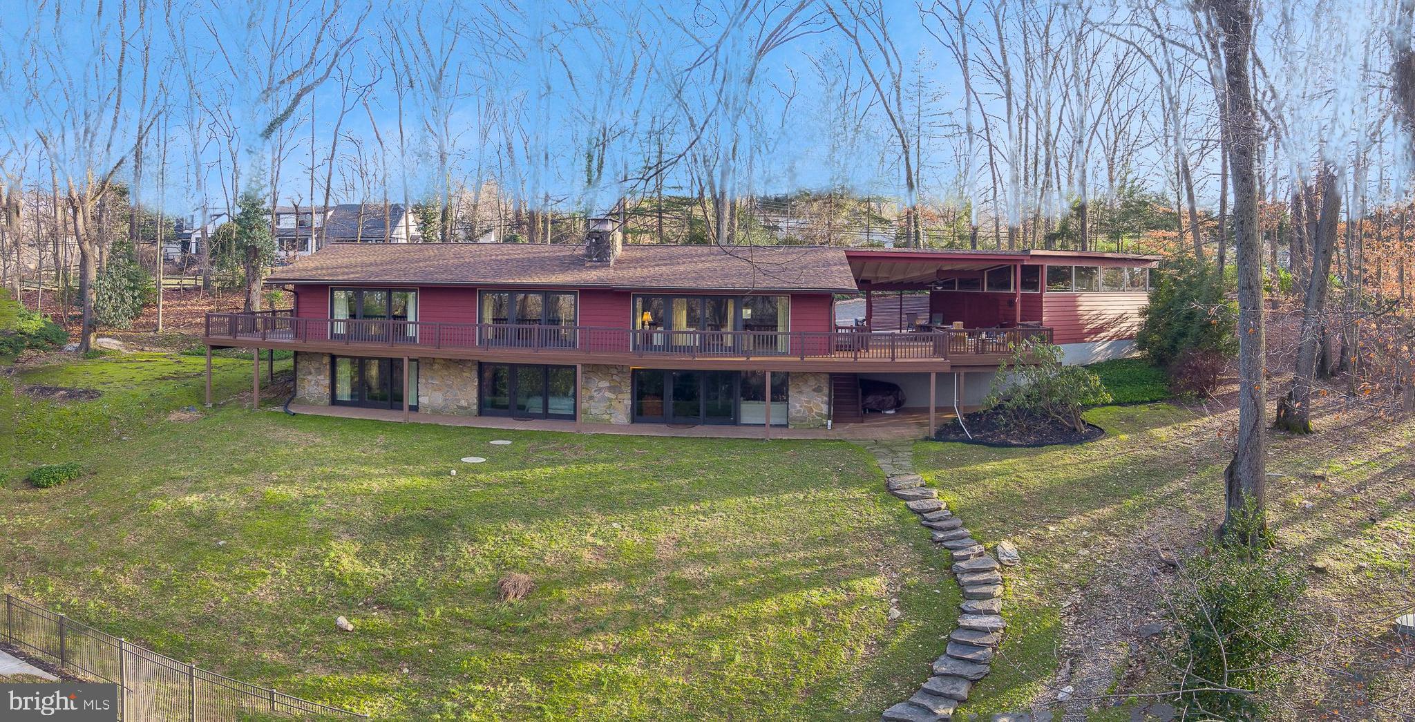 A rare find in Tredyffrin Township, this custom contemporary home is situated in a beautiful, private and quiet setting with an expansive pool and scenic views.  Updated with a careful eye to architectural details and design features, this home offers modern living at its finest!  
Welcome to 709 N Valley Forge Rd in Devon, located in the highly desirable neighborhood of the Shand Tract, a community known for its active neighborhood association and family-friendly events. This home offers a total of 3,480 sq. ft. of living space, situated on 2.5 acres of land with fabulous views, a true oasis.
Step inside the welcoming Foyer to an elegant living space flooded with natural light, providing an airy and inviting atmosphere. Beautiful hardwood flooring, high ceilings and front-to-back views tastefully set the stage for the remainder of the home. The Living Room features a stunning floor to ceiling stone fireplace shared by the Dining Room as a side backdrop wall. The Living/Dining Area also features glass sliders that open to a ¾ wraparound composite deck offering spectacular views from everywhere in the house and providing you with access to the outdoors at any given time.  The vaulted ceilings of the main Living/Dining Area and Kitchen join the rooms creating a special ambiance for everyday living and entertaining enhancing the sense of openness throughout the home. The Kitchen offers functionality and flair with attractive cabinets, granite countertops, subway tile backsplash, stainless steel appliances and a large center island with storage which is a perfect place to prepare food or serve a quick meal. There is also a separate wet bar area with wine/glass racks, modern glass backsplash, & wine refrigerator just steps away from the covered outdoor patio and adjoining deck, a perfect space for hosting social gatherings and enjoying indoor/outdoor entertaining. There’s a convenient Powder Room just off the Kitchen as well.  The Oversized 2-Car Garage is accessed via the covered Patio for easy covered access from the garage to the home.
On the opposite end of the house is the Primary Suite with gorgeous hardwood flooring, high ceilings, two sets of sliders to the wrap-around deck, a large walk-in closet with storage and a stunning modern en-suite Bathroom. There is an additional main floor Bedroom with a skylight and floor to ceiling windows that has a beautifully updated en-suite Bathroom which can also serve as a Hall Bathroom.  
A sweeping open staircase leads you to the lower level, where you will find an amazing Great Room with full wet Bar, space for four bar chairs, stone fireplace, a wall of glass sliders providing ample natural light and access to the expansive backyard with an inground pool and beautiful views.  The Great Room is an excellent space for hanging out, entertaining family & friends, enjoying pool parties, or just curling up with a good book next to the fireplace. Down the hall from the Great Room, you’ll find two additional spacious Bedrooms with sliders to the outdoors and large closets, a Full Hall Bathroom, and an unfinished Laundry/Storage/Utility Room with built-in shelving.
The outdoor spaces are equally impressive, featuring a partially covered Patio area, offering an ideal setting for al fresco dining. An inviting ¾ wraparound composite Deck to enjoy all the seasons have to offer. A beautifully landscaped backyard provides a serene retreat with the in-ground pool, creating a wonderful setting for outdoor living and entertaining. Immerse yourself in the perfect blend of tranquility, comfort, and convenience, creating a welcoming haven to call home. A spacious 2-Car Garage provides secure parking, complemented by additional driveway parking for guests.
An amazing chance to enjoy the best of both worlds - a serene private setting in a superb neighborhood within the acclaimed Tredyffrin-Easttown School District. Conveniently close to shopping, restaurants, highways, train & more.
