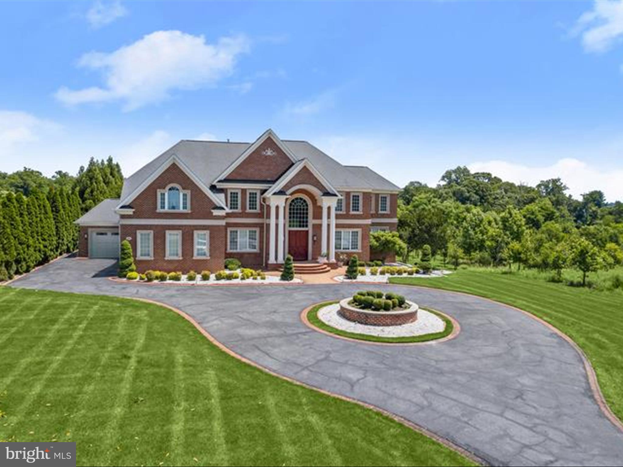 Experience unrivaled luxury and sophistication in this exquisite all-brick estate, featuring an extraordinary outdoor retreat and meticulously designed interiors. The backyard paradise is anchored by a heated Pentair IC-40 saltwater pool and a sprawling 1,100-square-foot pool house, complemented by multiple entertainment spaces and a thoughtfully crafted play area for children. Step inside to discover the recently renovated main level, a testament to fine craftsmanship and attention to detail. The grand foyer welcomes you with elegant lighting, stunning flooring, a gracefully curved staircase, and intricate architectural elements. Host gatherings in the formal dining room, showcasing a breathtaking vestibule ceiling, chair rail, and wainscoting, or retreat to the private study, complete with a gas fireplace and custom built-ins, ideal for remote work. The two-story family room, filled with natural light from expansive windows and French doors, offers picturesque views of the outdoor paradise. Adjacent is the custom-designed kitchen, a culinary masterpiece featuring a massive center island, professional-grade appliances, sleek cabinetry, a casual dining area, and a spacious walk-in pantry. A charming sunroom, a powder room, and an elevator complete the main level's offerings. The upper level is a sanctuary of comfort and luxury. The primary suite boasts a sitting area, a three-sided fireplace, a wet bar, and an enviable custom walk-in closet. The spa-inspired bath features an oversized shower, soaking tub, double vanities, and premium finishes. Three additional en-suite bedrooms and a convenient laundry room complete the upper level. The lower level is an entertainer’s dream, offering a custom bar, lounge area, playroom, exercise room, and a state-of-the-art home theater. A private in-law or au pair suite with a bedroom, full bath, and living area ensures flexibility for guests or extended family. Designed for modern living, this home is equipped with Andersen windows and doors, an elevator serving all three levels, a 600-amp electrical service, and a Generac 48kW natural gas backup generator. Perfectly situated in a prime Clarksville location, this residence effortlessly combines privacy, convenience, and unparalleled quality. This exceptional home has everything you need and so much more!