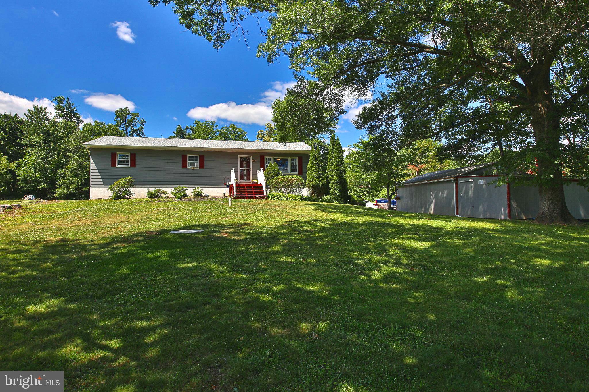 Welcome to Upper Perkiomen Valley! This charming 3-bedroom, 2-full-bath ranch home is nestled on over an acre of land, offering privacy, space, and beautiful wooded views.  Step inside to a bright and inviting living room, dining room, and updated kitchen, creating a comfortable layout for everyday living and entertaining. The convenient main-floor laundry room adds to the home's practicality, while newer windows provide energy efficiency and natural light throughout.  Outdoor living is a highlight, with an expansive deck overlooking a private backyard that backs to woods—an ideal setting for relaxing, dining outdoors, or enjoying nature year-round.  The finished lower level offers additional living space, featuring a cozy family room with a wood/coal stove to help take the chill off winter evenings. You'll also find a versatile office or den with outside access, a full bath, and ample storage space.  A detached garage with an attached storage shed provides plenty of room for vehicles, tools, and outdoor equipment.  Nature lovers will appreciate the home's convenient location just minutes from Green Lane Reservoir, where you can enjoy fishing, boating, camping, hiking and biking trails, horseback riding, ice skating, picnic areas, and more. Golf enthusiasts will also enjoy being close to Butter Valley Golf Course.  This well-maintained property offers the perfect blend of country living and outdoor recreation, all while providing easy access to local amenities. Ready for its next owners to add their personal touches and make it their own.
