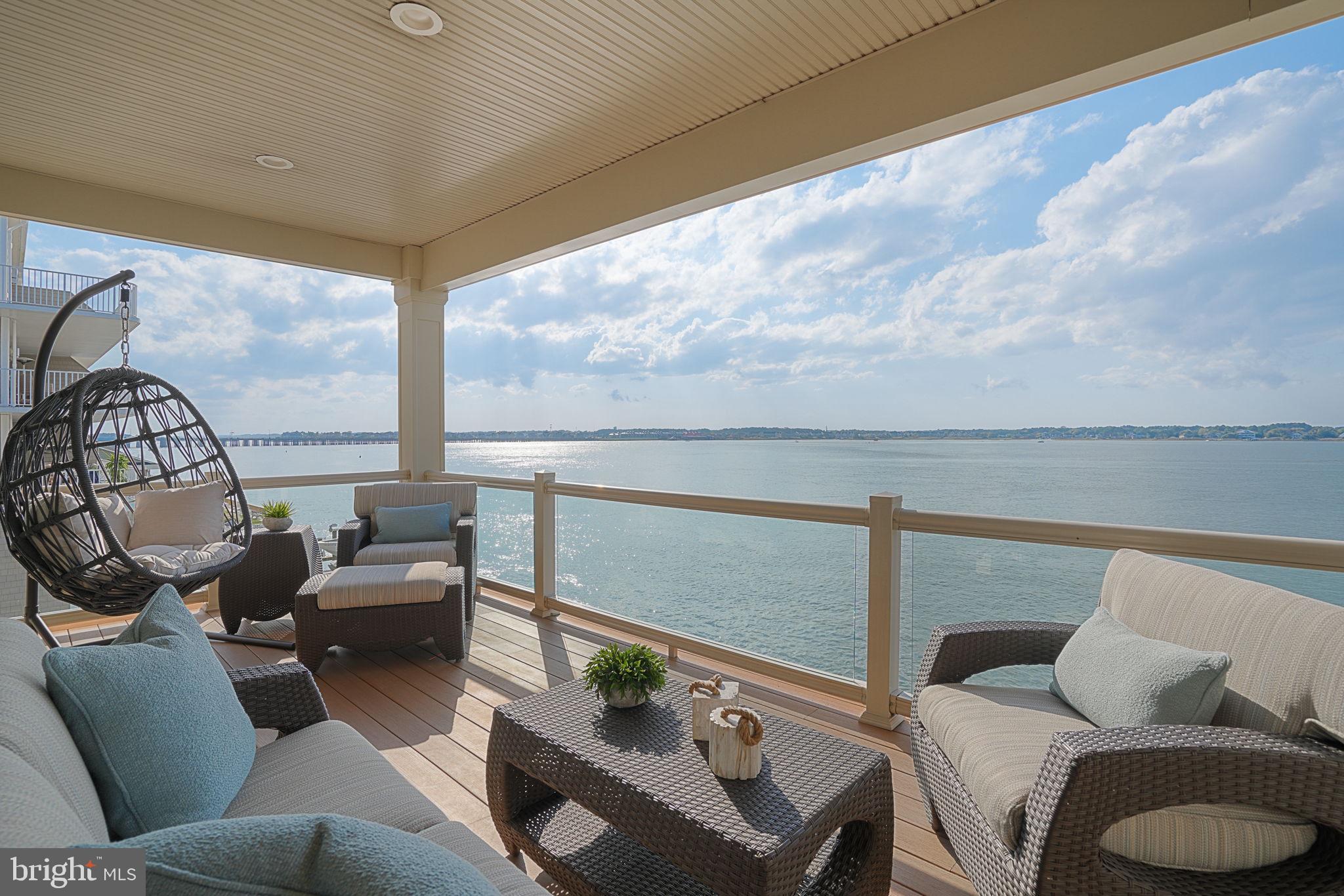Experience the ultimate in luxury coastal living with this exceptional bayfront home, better than new and boasting breathtaking sunsets over the bay from every level. Enjoy expansive decks overlooking the serene bay, offering an ideal setting for relaxation and entertainment. Every inch of this home exudes elegance, featuring designer coastal finishes and top-quality furnishings. It shows with natural light through floor-to-ceiling windows and doors, adding an airy, open feel throughout. The gourmet chef's kitchen is equipped with a built-in gas stove,  double wall oven, granite countertops and backsplash, center island, and custom cabinetry—perfect for the culinary enthusiast. With efficient geothermal heating and air conditioning, the home combines comfort with eco-friendly living. Boating enthusiasts will love the two deep-water slips, with one equipped with a new, remote-controlled 10,000 lb. boat lift, providing direct easy access to both the Bay and Ocean. The low-maintenance exterior is designed for coastal living, with a sleek metal roof adding to the home’s modern coastal appeal.  This home is ideal for families or entertaining, the handcrafted bar and recreation room on the first deck level open directly to the dock, making indoor-outdoor living seamless. For fishing enthusiasts, the convenience of fishing right from your deck is pretty cool.  In addition, its just a short stroll to the beach and boardwalk, yet tucked away, this home offers the perfect blend of convenience and tranquility. Combined with  NO HOA fees, this is one of the premier coastal properties available, offering an exclusive opportunity to enjoy waterfront living at its finest.
