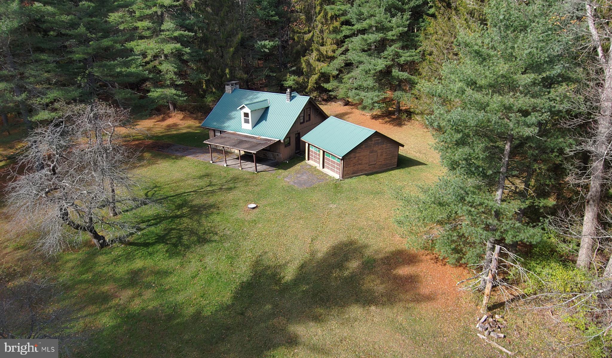 Discover the perfect mountain retreat just a short walk from beautiful Deep Creek Lake.  This quintessential cabin sits on 53  private acres bordering the 1,800 acre Deep Creek Lake State Park, offering direct access to endless outdoor recreation-fishing, swimming, boating, hiking, and more.

Inside, you’ll find a spacious living/gathering room featuring a stunning floor-to-ceiling stone fireplace, perfect for cozy evenings after a day on the trails.  The main level includes a comfortable bedroom, full bath, and a kitchen with plenty of space for family and guests.

The upper level features a large bedroom with built-in bunk beds and an open loft area, providing extra sleeping and lounge space.

Outside, there is  a large two-car garage with electric, ideal for storage or a workshop.  The 53 acre property is a rare find, featuring mature, never-harvested timber, 4 wheeler and hiking trails, a pond, and a stream, all teeming with local wildlife.

Whether you’re seeking a peaceful getaway, a family compound, or a nature lover’s paradise, this Deep Creek Lake cabin offers unmatched privacy and access to one of Maryland’s most beautiful destinations.