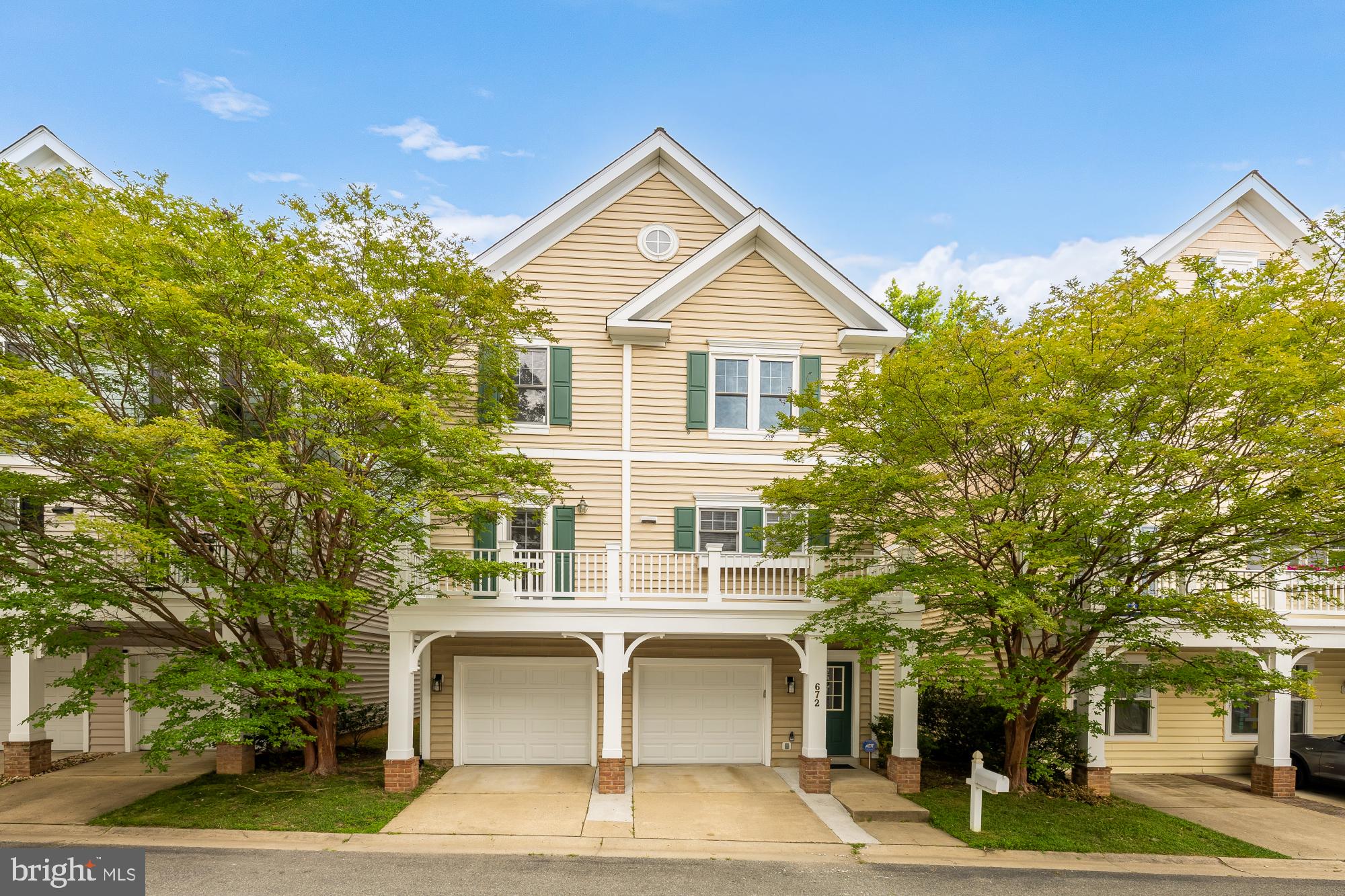Welcome to this light-filled Lakelands residence, ideally situated on a quiet tree-lined street just moments from Kentlands Market Square, Downtown Crown, and Rio. Offering a unique carriage-home design with a private entrance, oversized two-car garage, multiple outdoor living spaces, and low-maintenance ownership, this home blends comfort, convenience, and timeless appeal in one of Gaithersburg's most desirable communities.

The main living level is filled with natural light and enhanced by soaring cathedral ceilings, expansive windows, and an open-concept layout designed for both everyday living and entertaining. Rich hardwood floors flow throughout the living and dining areas, while a gas fireplace creates a warm focal point for gathering. The spacious kitchen features granite countertops, stainless steel appliances, abundant cabinetry, and a large center island with bar seating. Two private balconies extend the living space outdoors, providing ideal settings for morning coffee, al fresco dining, or relaxing among the surrounding mature trees.

Upstairs, the generous primary suite serves as a peaceful retreat, featuring vaulted ceilings, abundant natural light, a walk-in closet, and an en-suite bath complete with dual vanities, a soaking tub, and separate shower. A spacious secondary bedroom, full hall bath, and conveniently located upper-level laundry complete the bedroom level. The lower level offers exceptional utility with an oversized two-car garage, dedicated storage room, covered patio, and additional storage space rarely found in homes of this style.

Residents of Lakelands enjoy access to pools, tennis courts, walking trails, playgrounds, green spaces, and community events, all while being just minutes from shopping, dining, entertainment, and major commuter routes. A rare opportunity to enjoy spacious, lock-and-leave living in one of Montgomery County's most vibrant and amenity-rich neighborhoods.