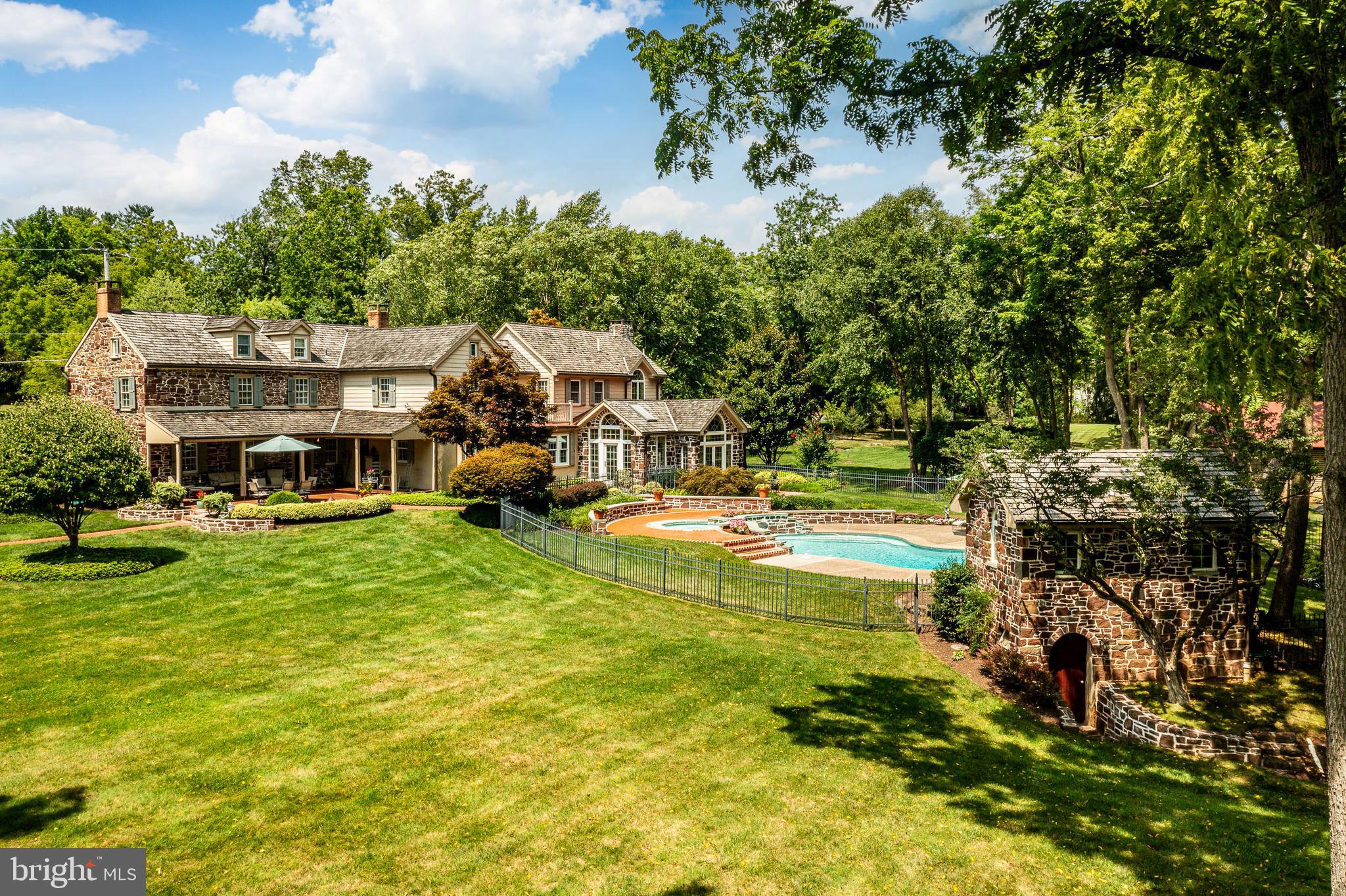 “Gwynwood Farm” An Extraordinary Historic Fieldstone Farmhouse & Homestead. Circa 1700’s "Gwynwood Farm" is a showcase property, a postcard-worthy, and captivates one with the allure of timeless irreplaceable elegance, charm, character, period details, and unique touches. A fieldstone farmhouse that has been impeccably restored and preserved with master craftsmanship. Gwynwood Farm is nestled on 5 acres and embraced by Gwynedd’s splendor of nature’s tranquility, a sought-after part of Montgomery County, Pa.  The natural tranquility of this historic homestead is further enhanced by a bordering neighbor, a Wildlife Land Preserve of over 250+ acres that offers a boundless, serene, idyllic feel. Yet “Gwynwood Farm” is conveniently located to Philadelphia & enjoys the transportation gateway of Accela high-speed railway and interstate I-95 to Manhattan, Boston, and Washington metropolitan hubs, employment, and cultural centers. Along with the easy escape to vacation and the relaxation of NJ and Delaware beach towns. The Quaint villages of Skippack, Lederach, and Mainland are nearby, as are the downtown districts of Ambler, Lansdale, and Doylestown. Offering downtown shopping districts, parks, culture, artisan, professional services, entertainment, dining, & nightlife. “Gwynwood Farm” is a spectacular homestead with the field stone farmhouse as the centerpiece. It has passed through very few owners and has been for sale only once in the past 100 years. For the past 41 years, it has been under the loving stewardship of the current owners. The current owners purchased “Gwynwood Farm” to embark on a meticulous & loving journey of what would become their “prided & jewel residence”. From sipping wine in their wine bar to hiking through the land preserve, they created lifelong memories alongside countless hours, months, and years of commitment and dedication to restore, preserve, & expand this magnificent homestead. Embracing a mindful discipline of maintaining its original charm, character, & craftsmanship while masterfully blending seamlessly the old with the new. Their plethora of major renovations continued for over 10 years and entailed a complete restoration & preservation of the original farmhouse that included hand hewn beams, exposing & repointing interior and exterior 2’ thick stone walls, extensive custom millwork, wainscoting, custom built-ins, random width hardwood flooring, re-plastering interior walls & ceilings, and replacement of all mechanical systems - plumbing, electric, heating and HVAC systems. The kitchen was completely refurbished from the ground up with a new foundation, radiant heat flooring, abundant custom cabinetry, built-ins, a center island breakfast bar for morning coffee or meals-on-the-go, & SS appliances, the deep-set triple window provides a bird's eye view of the rear gardens & pool all of which combines to be any gourmet’s delight. The two original walk-in stone fireplaces in the living & dining rooms were refurbished & offer perfect ambiance and cozy warmth on cold winter days as they did in centuries past. Finishes & decorating touches were applied with care, to keep with the time period while complementing the elegance, grandeur, charm, & character of these exceptional living spaces. Additions were carefully planned & executed. From seamless architecture & floor plan to hardware, millwork, doors, windows, flooring, finishes, & custom-built-ins. The charm, character, elegance, & timeless allure continue throughout by covered porches, Dutch and transom top etched glass doors, deep windowsills, wide planked random width wood flooring, beaded, crown and chair rail moldings, period built-up custom mantels, walk-in stone fireplaces, raised panel wainscoting, interior exposed stone walls, shuttered windows, all washed w/ natural daylight. This centerpiece is set on 5 acres of palatial parklike paradise!