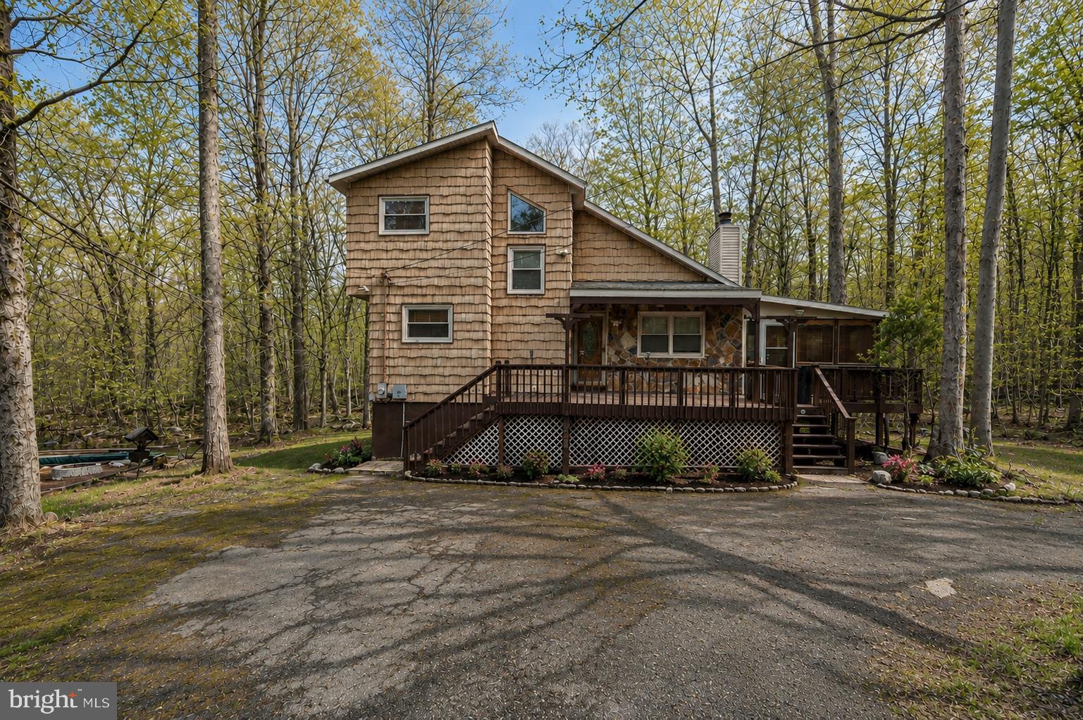 Welcome to this beautifully maintained 3 bedroom, 2.5 bath detached home, backed in the woods, nestled in desirable Coolbaugh Township, offering the perfect blend of comfort, privacy, character, and scenic surroundings. Step inside to find hardwood floors throughout and a stunning family room featuring a vaulted ceiling, skylights, ceiling fan, and a charming brick wood-burning fireplace with mantel. The spacious kitchen is equipped with modern appliances, a ceiling fan, and a breakfast peninsula accented by pendant lighting—ideal for casual dining and entertaining. A formal dining room showcases elegant baseboard and crown molding along with chair rail detailing. Enjoy year-round relaxation in the sunroom with French doors, floor to ceiling windows on two sides, wood-paneled walls and ceiling, and direct access to the deck. The first floor also includes a guest bedroom, and a half bath. Upstairs, the primary suite features a unique pocket door, a ceiling fan, and three closets, along with access to a full bath featuring a granite-topped vanity with vessel sink and a tub/shower combo. Also on the second floor there is another bedroom. The fully finished daylight walkout basement provides additional living space with recessed lighting, a game area, a pool table area, a poker table area and a screening room. Also in the basement, a large workshop/storage area and a convenient laundry room leading to a full bath with walk-in shower. Outdoor living is just as impressive with dual walkout decks in the front and side. Connecting them there is a specious 4 season enclosed porch, featuring a full wet bar and panoramic wooded views. A large hot tub, utility shed, off-street, multiple car, driveway parking make this home a true retreat both inside and out. Conveniently located close to major highways I-80, I-280, I-84 and PA-611 for easy commute. Close to Shopping, Restaurants, Commuter Bus, Ski Resorts, Indoor Water Parks, Mt. Airy Casino and so much more!