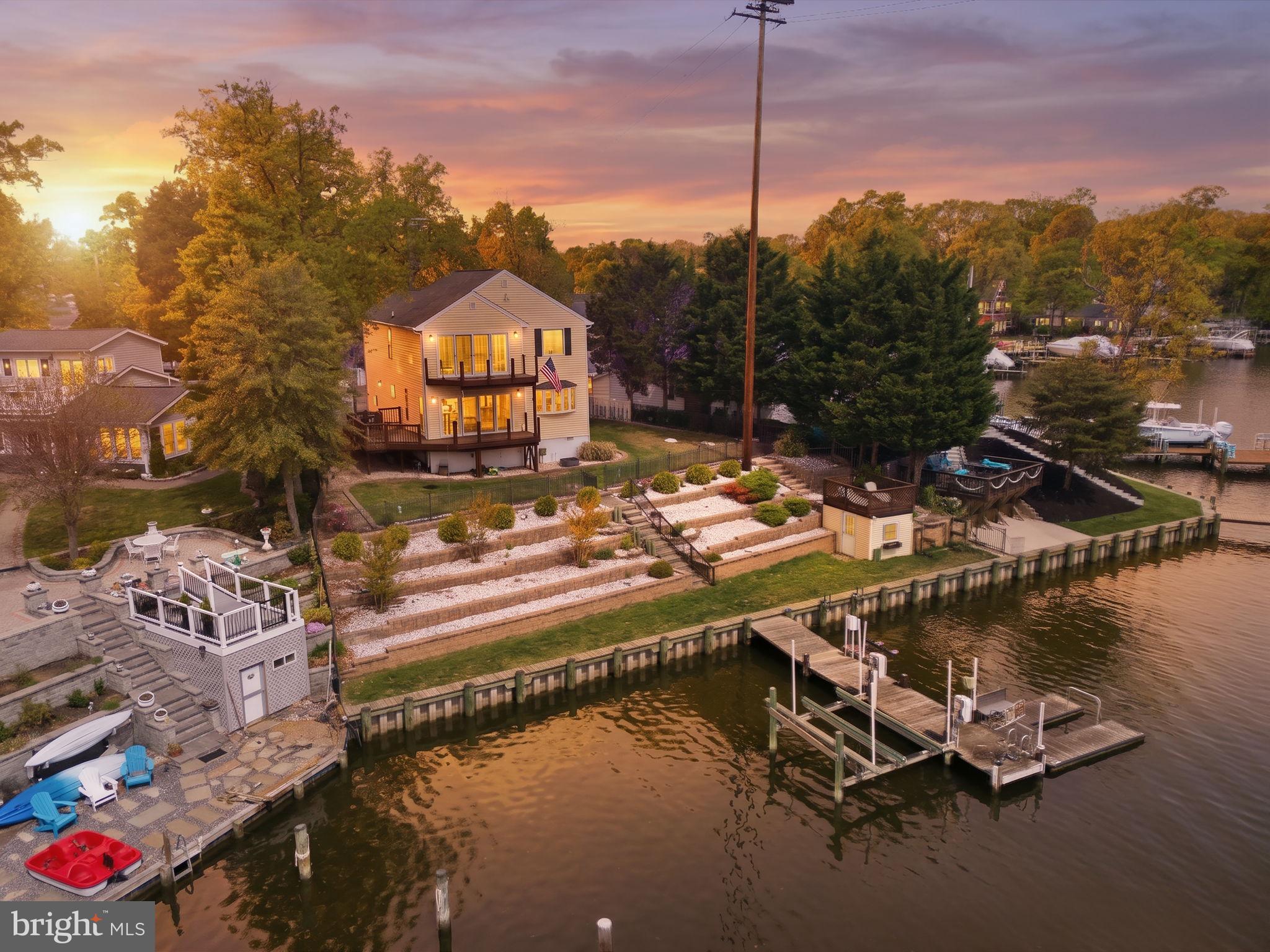 BUYER FINANCING FELL THROUGH- their loss is your gain! Waterfront living doesn't get better than this. With 100 feet of prime shoreline, deep water access, and a fully outfitted pier featuring a 10,000 lb boat lift and jet ski lift, this property was made for people who live on the water. A floating kayak launch, kayak racks, and a charming crab deck/boathouse complete the waterfront experience, while the 2023 bulkhead replacement means you can enjoy it all with total peace of mind.
The grounds have been thoughtfully elevated with a new four-tier stone retaining wall and fresh landscaping that balance beauty with function. The deck with glass panel railing lets the water views take center stage — unobstructed, uninterrupted, and absolutely breathtaking. Step inside and the open floor plan opens up around hardwood floors, a kitchen with granite countertops and a newer refrigerator, and a generous primary suite with a spa-style bath and newer four-door slider that connects seamlessly to the outdoors. A one-car garage with workshop space rounds out the practicality.
And the perks extend beyond your property line, including community amenities such as a private beach and boat ramp, offering even more ways to get on the water.
If you've been waiting for the one that checks every box, this is it. Come see it for yourself, and start loving being home.