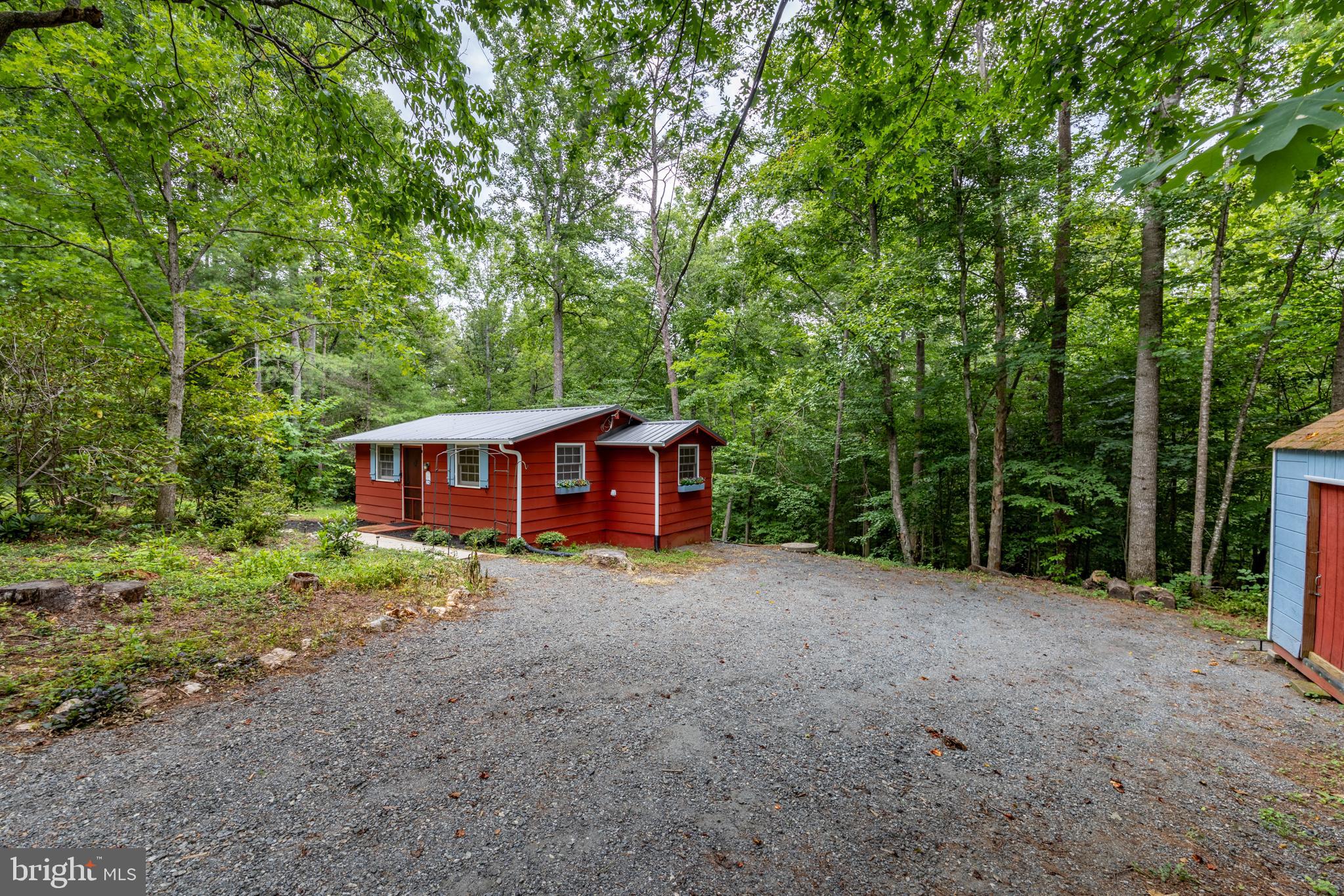 Escape to your own slice of nature in this cozy 1-bedroom, 1-bath cottage tucked away on 4.1 wooded acres, with Garth Run access on the back of the property.  Inside, the home offers warm, natural charm with wood cabinetry and butcher block countertops in the kitchen, complemented by newer stainless steel appliances that bring a modern touch to the classic cottage feel. Recent updates include a new roof, new gutters, a new hot water heater, and a newer washer and dryer. Located in the Laurel Mountain HOA residents can enjoy access to a stocked pond just across the road — perfect for fishing, relaxing, or an evening stroll. Whether you're looking for a full-time residence or a weekend retreat, this cottage offers a rare combination of privacy, updated systems, and a peaceful wooded setting.
