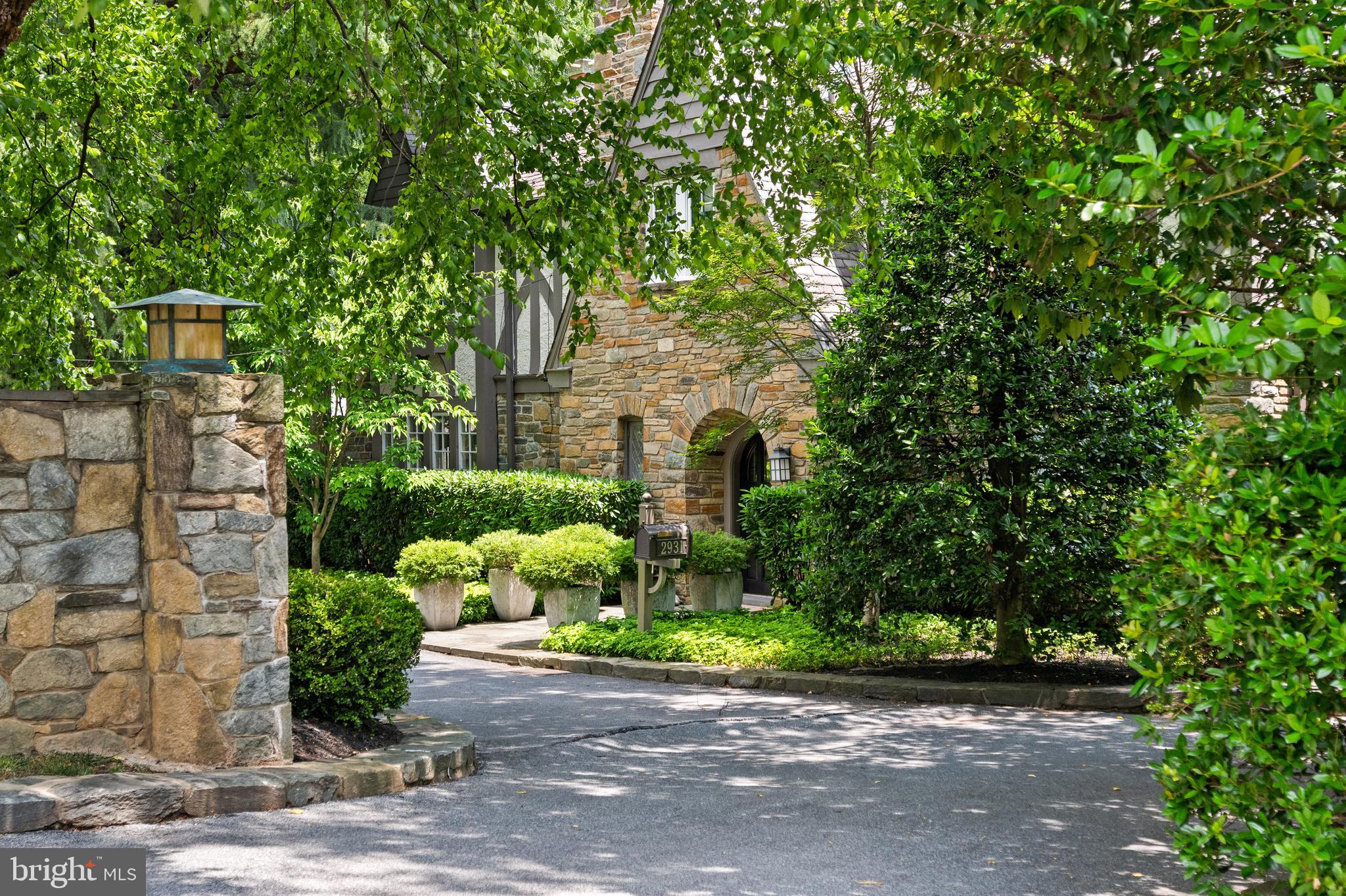 This classic 1920s Tudor beautifully blends timeless architectural character with thoughtful updates completed over the years, including a significant renovation in 2018. Tucked behind handsome stone walls on an expansive lot, the residence offers a rare sense of privacy and seclusion in one of Washington's most coveted neighborhoods.
Inside, the grand 30-foot living room is distinguished by its soaring ceiling and abundant natural light, creating a dramatic yet welcoming space for both everyday living and large-scale entertaining. Throughout the home, windows frame lush greenery, fostering an exceptional connection to the surrounding landscape and a sense of tranquility rarely found in the city.
The heart of the home is the chef's kitchen and casual living area, which seamlessly opens to a generous terrace and the beautifully level, verdant grounds. The primary suite serves as a true sanctuary, featuring a spa-inspired bathroom and refined finishes.
Completely move-in ready, the property offers the rare convenience of a through-drive with entrances from both Foxhall Road and Hawthorne Street, providing exceptional flexibility and ample parking, along with an attached garage.
This is a refined, private retreat where historic charm, modern comfort, and a remarkable connection to nature come together in a premier Washington setting.