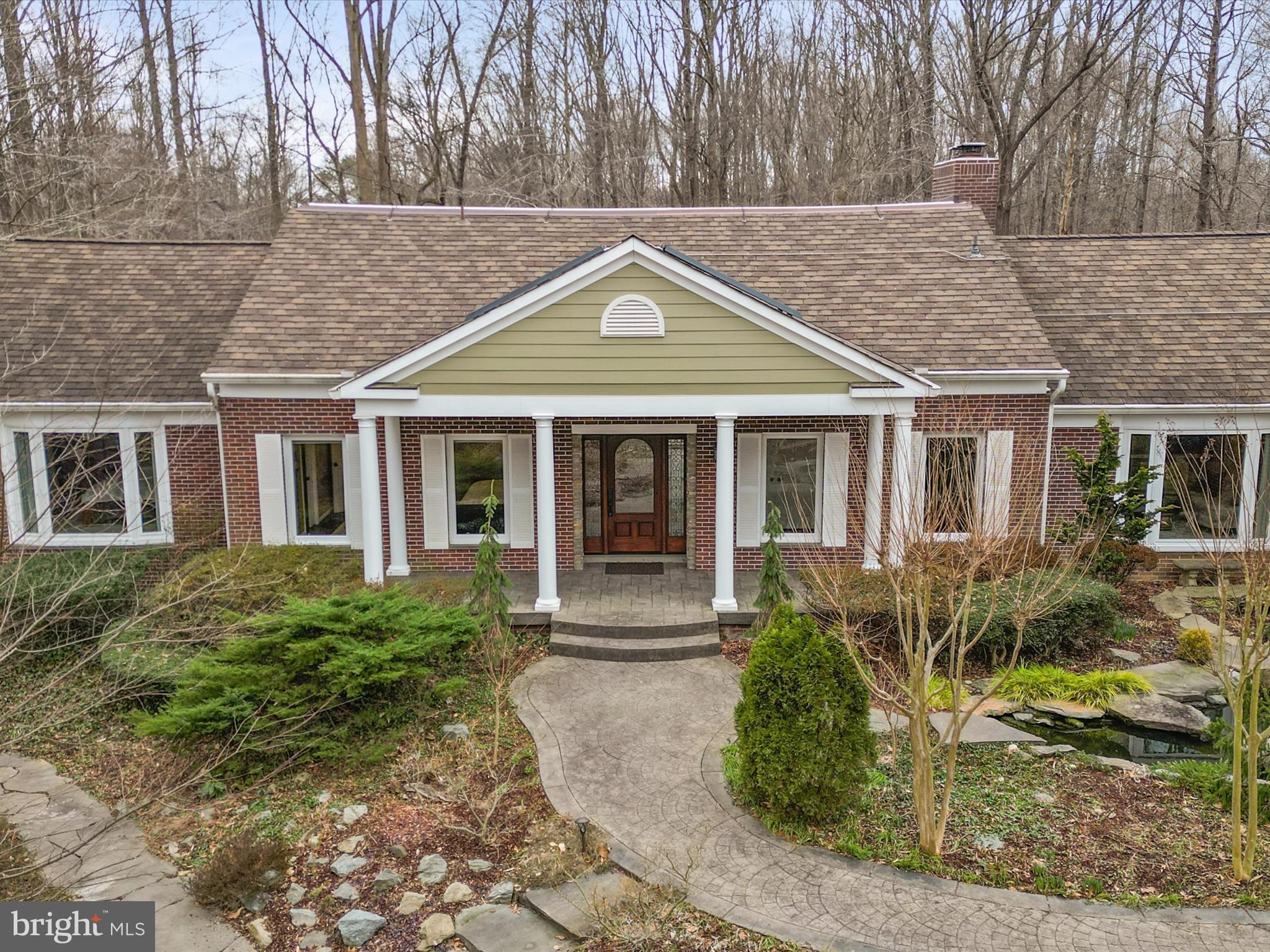 Live in harmony with nature in your highly energy-efficient 4 bed 3.5 bath home with discrete solar panels, silent backup battery power and 4-zone geothermal heating/cooling that costs about $840 per year to run. The privacy and flow of this home offers indoor / outdoor living with a covered deck that shelters you from sun and rain for dining and relaxing, stone patio with a fireplace, and solar-heated swimming pool. Deer fencing surrounds the 3.7 acre park-like property that includes a creek, small wildlife pond with water lilies and a breathtaking range of mature plantings of trees, shrubs and flowers that delight year-round. Trails entice you to discover the secrets of this organic yard in which birds, butterflies and wildlife thrive, minutes from shops, restaurants and commuting options. The spacious first floor primary bedroom offers separate his and her walk-in closets and en-suite luxuries including a towel warmer and copper tub, while the second bedroom also has its own full bath. The kitchen offers high-end Cafe and Miele appliances and an eating area with a wall of windows, flowing to a dining room with wood-burning fireplace insert, a living room with second fireplace and integrated surround-sound, and a sound-insulated office. Solid wood hand-scraped hickory flooring with wainscoting and crown molding continues upstairs leading to two additional bedrooms and a large bathroom. Storage abounds with three walk-in attic areas. A finished walk-out partial basement with insulated and carpeted flooring provides an exercise area, kids play area, or media room. The inviting low maintenance exterior features brick, architectural shingles, luxury PVC decking, and custom solid wood entry and garage doors. HOA clears snow, maintains private roads, and offers miles of neighborhood woodland trails.
Plus you are so close to the town of Clifton with shops and restaurants, Burke Lake Park and the best schools around.  WOW a 10+++