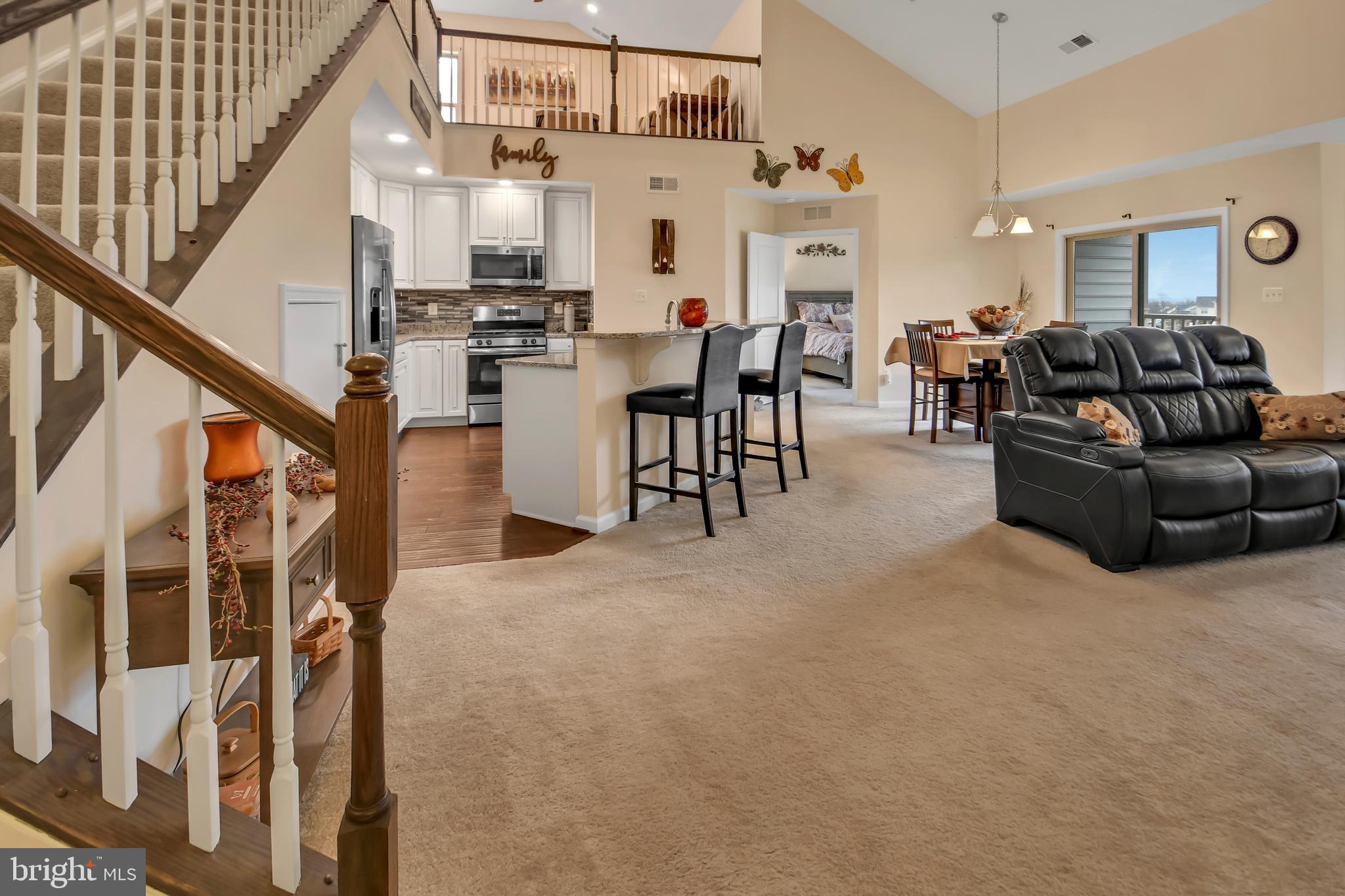 This condo in the highly sought-after Linton at Ballenger community is a must-see! Step inside and be greeted by the open-concept floor plan, grand high-volume ceilings, and upstairs loft. This beautifully upgraded condo feels like new and features two spacious bedrooms with two large ensuite bathrooms and plenty of living space. This unit is conveniently located on the fourth floor, with easy elevator access. The kitchen is a chef's delight–featuring upgraded 42" cabinets, custom tile backsplash, stainless steel appliances, granite countertops, a large island, a breakfast bar, and a roomy pantry. The kitchen is seamlessly connected to the living area, creating the ideal space for entertaining guests. In the living area, enjoy the cozy gas-burning fireplace and dual exits to the private covered deck–your outdoor retreat. The standout feature of this condo is the added loft! Transform it into your desired space—an additional entertaining area,  play zone, or extra storage. The possibilities for the loft are limitless! The primary bedroom is a luxurious escape with two large closets and an ensuite bathroom. The primary bathroom features a dual granite vanity, upgraded cabinets, a large tiled shower with a convenient built-in bench, and a linen closet for extra storage. The equally spacious secondary bedroom boasts a large closet and an upgraded ensuite bathroom with a granite vanity, upgraded cabinets, and a tiled shower with a built-in bench. Enjoy the convenience of an in-unit washer and dryer and an always-ready tankless hot water heater. Need extra storage space? The foyer features a coat closet and an oversized storage closet, and there is additional storage under the stairs to the loft. Residents can take advantage of the amenities Linton at Ballenger provides, including a clubhouse with a community room, gym, swimming pool, playgrounds, and a community athletic field. The low condo fees cover all these amenities, as well as water and sewer. Located just minutes from Downtown Frederick shopping, commuter routes, and more, this home is a must-see!