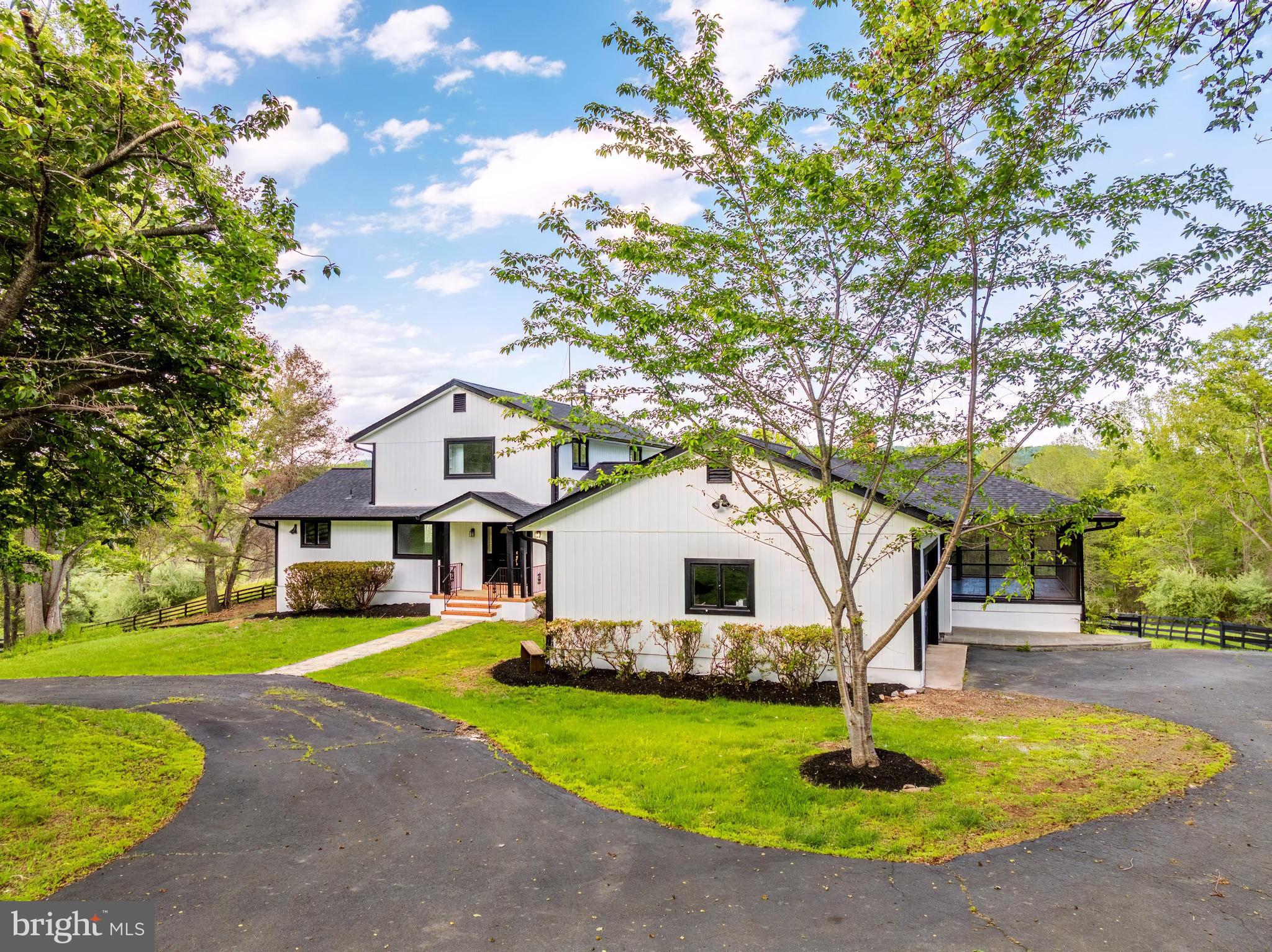 Nestled in the serene landscapes of Marshall, VA, this exquisite contemporary residence, set on an expansive 8.3-acre lot, offers a luxurious lifestyle defined by elegance and tranquility. The property has undergone a major renovation in 2026, ensuring modern sophistication while preserving its timeless charm. The exterior features a stunning wood siding façade, harmonizing beautifully with the natural surroundings. A circular paved driveway leads to an oversized attached garage, providing ample parking for guests. The property boasts a dedicated barn/stable, catering to equestrian enthusiasts, while the lush, private grounds are bordered by trees and open space, creating a secluded retreat. Step outside to revel in breathtaking panoramic views of the mountains and valleys, where every sunrise and sunset paints a picturesque backdrop. The meticulously landscaped rear yard invites outdoor gatherings, while the surrounding wooded areas offer a sense of peace and privacy. Inside, the home features four spacious bedrooms and three and a half luxurious bathrooms, complemented by two elegant wood-burning fireplaces that add warmth and character. The fully finished daylight basement provides additional living space, perfect for entertaining or relaxation. This property is not just a home; it's a lifestyle, offering the perfect blend of luxury, nature, and equestrian amenities. Experience the ultimate in refined living, where every detail has been thoughtfully curated for comfort and style.