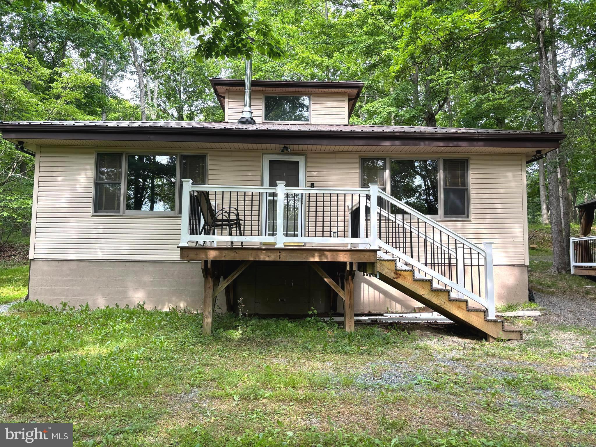 Great opportunity to own a  home in wild and  wonderful West Virginia.  Perfect property for a weekend getaway or a full time residence. No need to worry about stairs. The main level has two primary bedrooms with private bathrooms.  One bathroom has a shower tub and the other bathroom has  a walk-in shower. Both rooms have large walk- in closets.  The great room is  35 x 11 with a wood stove that will heat the majority of the house.  There is a third bedroom with a half bath for guests.  There is a large 4 season sunroom 35x 11 in the back of the house with a tile floor that keeps the room cool in hot weather.  The gazebo and hot tub are great for entertaining. The 5.2 acres are secluded with tall mature trees. Property is just a 15 minutes from shopping areas.