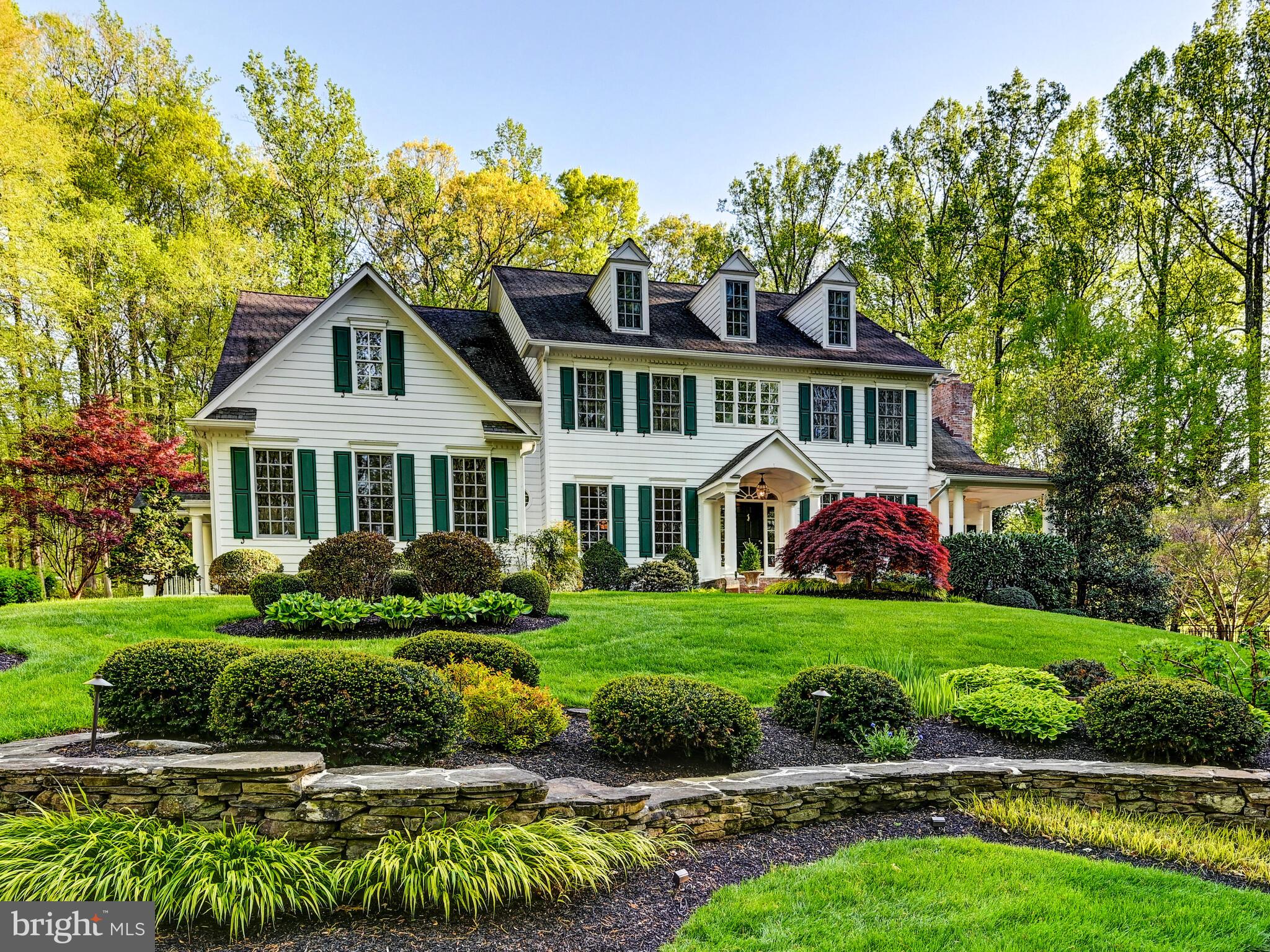 Spacious and distinctive colonial home located in the wonderful Wesley Chapel Woods community in Monkton. Nestled on over 1 acre of pristine landscape, providing privacy and a serene setting. The property is set amongst the woods enhancing the seclusion and natural beauty while still being in the midst of a neighborhood. This classic architectural style is synonymous with symmetry and specific design elements that are not to be disappointed. Interior highlights comprise of the formal entryway flanked by living and dining rooms, Florida room and office with private porches, sunken family room and numerous fireplaces adding warmth and charm to the various rooms. Open, eat-in kitchen with large island and additional table space makes for a perfect gathering spot for family meals and entertaining. The mudroom conveniently located off the kitchen leads to an attached 3 car garage with side entrance for extra ease. Split staircase to the upstairs offers practicality for all. Offering 6 bedrooms and numerous bathrooms including an incredible primary suite and separate office/sitting area plus 3rd floor bonus play area perfect for family flexibility. The lower level features a recreation room ideal for all fitness needs, crafting, and an extra family room exiting to the outdoor tiered side and backyards. The fabulous deck overlooks the maintained gardens and plantings, creating a retreat-like atmosphere perfect for relaxation or hosting of events. The beautifully designed custom saltwater swimming pool with stone fountain is built for the most particular of pool enthusiasts in an unbeatable setting. Hot tub and the fire pit are a definite hit too! All of this meant for enjoyment throughout all the seasons to come all the while accomodating different lifestyle needs with abundant indoor and outdoor spaces. Finally but not least, let's not forget to take advantage of everything Monkton has to offer in its schools, culture, recreation, accessibility and much more.