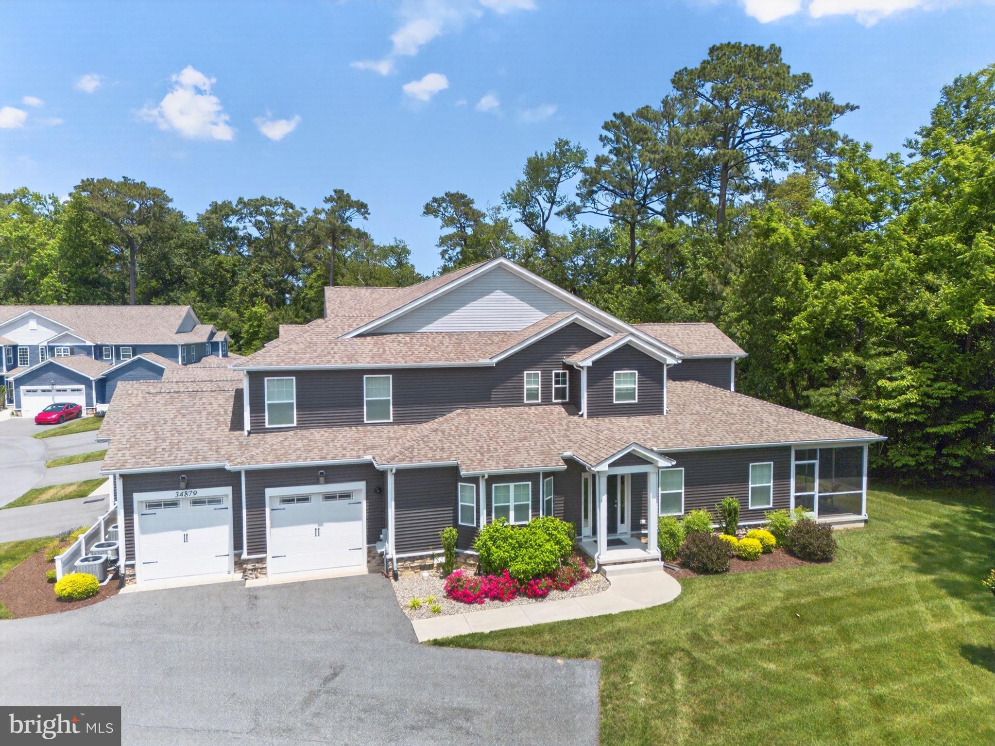 Welcome to 34879 White Shell Court, a 3-bedroom, 3.5-bath home in Woods Cove with 2,208 square feet of comfortable living space in Rehoboth Beach. With multiple private suites, an open main level, a screened porch, a covered patio, and a large two-car garage, this home gives you plenty of room to spread out, host guests, and enjoy life just minutes from the beach!

The first floor centers around a bright, open layout where the kitchen, dining area, and living room all flow together naturally. The kitchen features warm wood cabinetry, a large island, and a clear view into the main living spaces, making it easy to cook, gather, or entertain without feeling separated from the rest of the home. The living room stretches over 25 feet and opens to the screened porch through large glass doors, bringing in plenty of natural light.

A private first-floor suite adds flexibility, with its own walk-in closet, full en-suite bath, and direct access to the covered patio. A separate laundry room, powder room, and attached two-car garage add practical convenience without taking away from the open feel of the home.

Upstairs, the home offers two more private suite-style spaces. The primary suite includes a spacious bedroom, walk-in closet, and en-suite bath with a double vanity and private toilet area. The other suite includes its own full bathroom and a landing area that gives the room a little extra separation.

Outdoor living is one of the best parts of this home. The screened porch is perfect for relaxing with fresh air, while the covered patio and green backyard create a great space for dining, coffee, or winding down after a beach day.

Woods Cove adds even more to enjoy, with amenities including a playground for young kids & a community pavillion. The location is less than five miles from popular downtown Rehoboth Beach and close to Cape Henlopen State Park, Tanger Outlets, Dogfish Head Brewing & Eats, and many more shops, restaurants, and everyday conveniences.

Schedule your private tour today and come see what makes this home such a great opportunity in Rehoboth Beach!