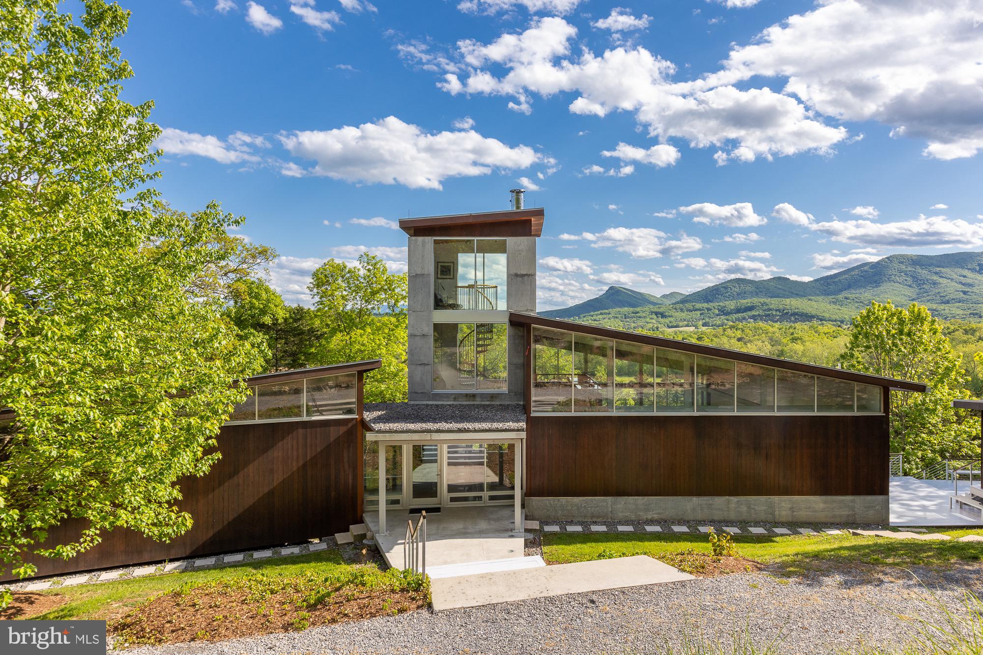 Atop the Shenandoah Valley overlooking Massanutten Mountain and the North Fork of the Shenandoah River, this breathtaking modern home is a fine representation of architect Jim Burton's internationally celebrated work. The main home is built of insulated concrete with steel framing, a butterfly roof, and the amazing 40ft tower with some of the best views you'll ever find in our region.  The rich amenities add to the getaway, with a standalone modern guest house enjoying a private pond, outdoor living spaces, even an outdoor sauna and spa. Meander across the fields to the rivers edge for picnics, swimming, bocce, archery, canoes and kayaks, or throw a summer party. It is an incredible home, on an awe inspiring site.
