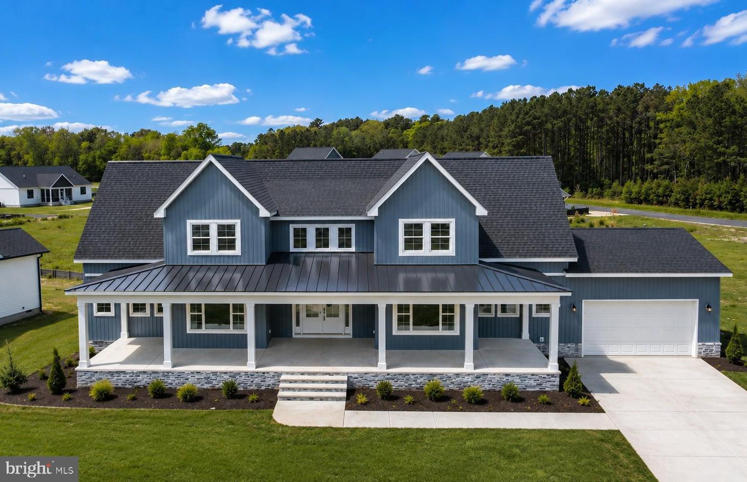 This brand-new 5-bedroom, 3.5-bath coastal farmhouse blends modern luxury with timeless design. Thoughtfully crafted with premium finishes throughout, it features 9-foot ceilings, an 18-foot vaulted great room with a custom fireplace, built-ins, and an open floor plan perfect for entertaining and everyday living.
The designer kitchen is truly the heart of the home. It showcases solid wood cabinetry in soft sage and dove tones, Calacatta Prado quartz countertops and backsplash, and a large center island with a built-in microwave, prep sink, and elegant brass chandelier. The kitchen is equipped with high-end GE stainless steel appliances, including a gas range with an air fryer, French door refrigerator, and a quiet dishwasher. A pot filler, brushed brass fixtures, and soft-close cabinetry add to the thoughtful details, while a spacious walk-in pantry provides additional storage and convenience.
The first-floor primary suite offers a relaxing retreat with a spa-like bathroom featuring a freestanding soaking tub, double vanity, and tiled shower. Upstairs, you will find additional bedrooms, a versatile loft, and a beautifully appointed bathroom.

This home is designed with efficiency and durability in mind, featuring a Bosch dual-zone HVAC system, Rinnai tankless water heater, sound-insulated six-inch exterior walls, and a sprinkler and fire suppression system. Outside, enjoy covered front and rear porches, a finished two-car garage, and a newly paved driveway.

Every detail of this home reflects quality, comfort, and thoughtful design, creating an exceptional coastal living experience.

Photos are digital renders.