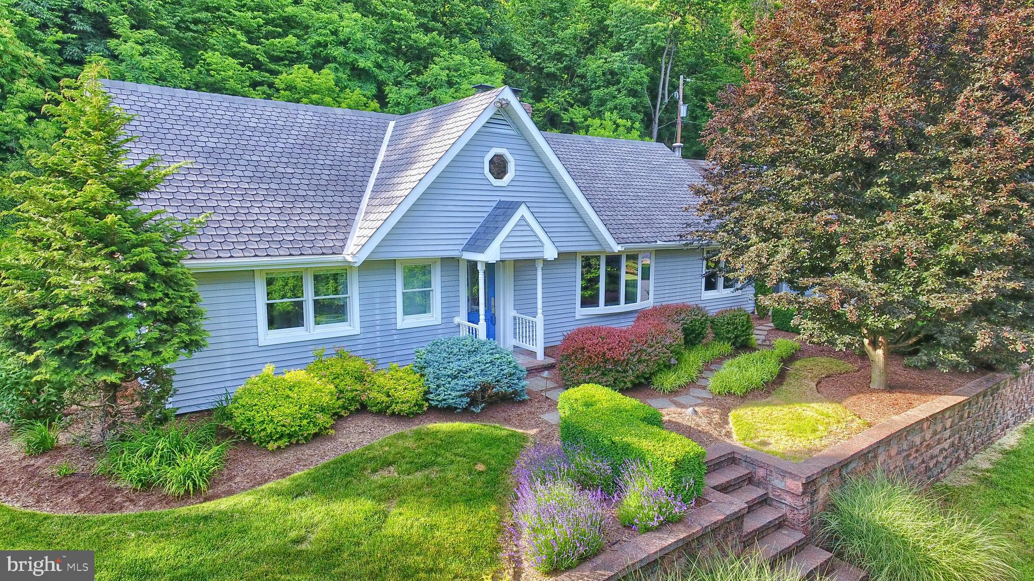 Looking for your own private paradise?! THIS.IS.IT.  An amazing opportunity to own this beautiful home on top of the mountain surrounded by over 7.5 acres of serenity.  There is so much to love about this property inside and out! This UNIQUE home boasts over 4, 300 square feet of meticulously maintained living space and has been completely updated, freshly painted, newly carpeted and is MOVE IN READY!  A cozy covered front porch welcomes you and is a wonderful space to relax and take in the views of the breathtaking surroundings. You will fall in love the second you walk in the door. An open living room/sitting area with a double sided wood burning fireplace flows into the kitchen area. The gourmet kitchen is truly unique, perfect for entertaining and especially perfect if you love to cook! An amazing Viking stove and Sub Zero refrigerator are what any home chef would want in a DREAM KITCHEN.  Off the kitchen there is a great first floor laundry room and beyond that a massive family room with vaulted ceilings, floor to ceiling windows and an exposed second floor. Step out back onto a beautifully hardscaped patio/courtyard area that features a covered pergola with an outdoor kitchen complete with a bar, built in grill and refrigerator! Back inside there is a large FIRST FLOOR MASTER SUITE , absolutely gorgeous BRAND NEW MASTER BATH and a huge walk in closet. Upstairs to 3 more bedrooms, a full bathroom, a wonderful open bonus loft space and an additional finished room that could make a great office space,  playroom, additional storage space or even a small 5th bedroom.   Need storage? There is an over sized 2 car attached garage and an amazing detached, completely wired 4 BAY WORKSHOP with stairs to the upper level for storage galore! A handyman or mechanic's dream space! Love to GARDEN? There is a fabulous enclosed garden area with several large boxes ready to be planted. Love to fish or relax near the water? There is an incredible fully stocked pond with your very own dock and outdoor fire pit.   Also worth noting is the 50 year shingled roof,  New furnace in 2015,  New water system installed in 2017, Septic inspected in 2018, and brand new AC Unit in June of 2020 for peace of mind. This truly is a special place to call HOME.  https://vimeo.com/431411983/cf8d3d56ae