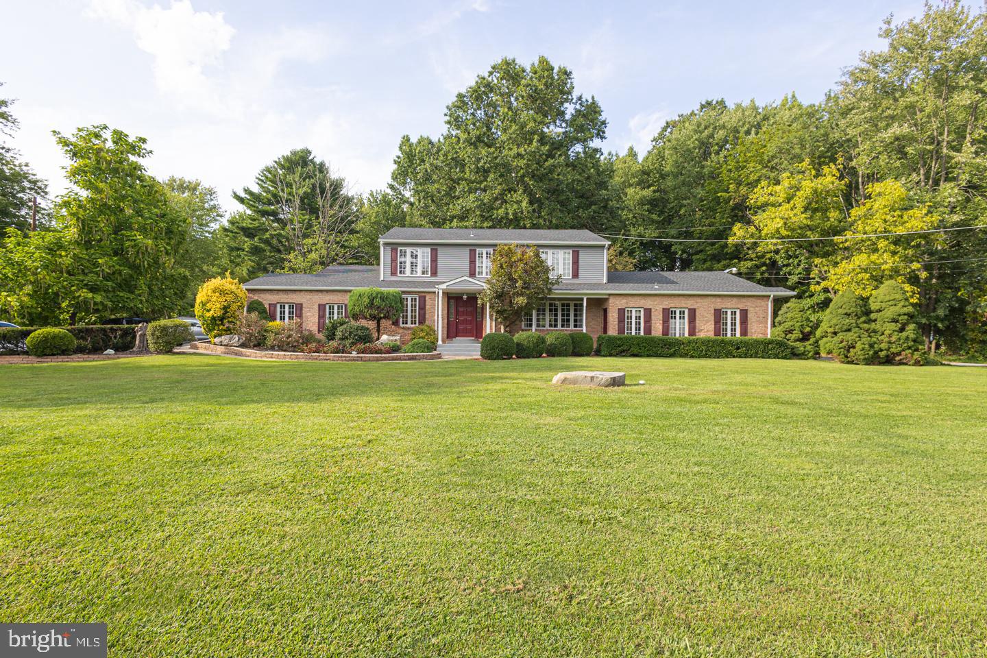 Start the new year in a new home! Unique opportunity in Lower Makefield. Work from home in this spacious four bedroom colonial on 2.98 acres with attached office.  Handsomely clad in brick and grey siding, the home has tremendous curb appeal. Inside the covered front porch, the marble tiled foyer leads guests to the formal living room. The generously sized room offers rich hardwood floors that seamlessly flow into the adjacent dining room. The kitchen includes a large center island with granite countertops and tiled backsplash. A row of windows provides a view of the private backyard. The bright and spacious family room was remodeled in 2022 and features a stone clad woodburning fireplace, interior access to the two car garage, vaulted ceilings and recessed lighting.  Patio doors with vented sidelights provide access to the oversized composite deck, built with entertaining in mind. The first floor also includes a remodeled half bath and brightly lit first floor office. On the second floor, the master bedroom features a stunning built-in headboard and ensuite bath. There are three additional spacious bedrooms and a large hall bath. New flooring in the bedrooms and hallway.  Family and guests will enjoy the finished basement featuring a second family room area with  an electric fireplace, charming built-in bar with sink, exercise area and sauna.  Attached to the home is a professional office space with two separate entrances. The office includes three private exams rooms, reception area, and off-street parking for 4 cars. The property offers a sun-drenched front yard with mature landscaping and outdoor lighting. The backyard provides many opportunities to enjoy nature with the stone firepit, terraced rock retaining walls, and large stone clad fishpond.  Rare to find a better combination of property size, location and amenities!  Minutes to the shops and restaurants of Yardley Borough.