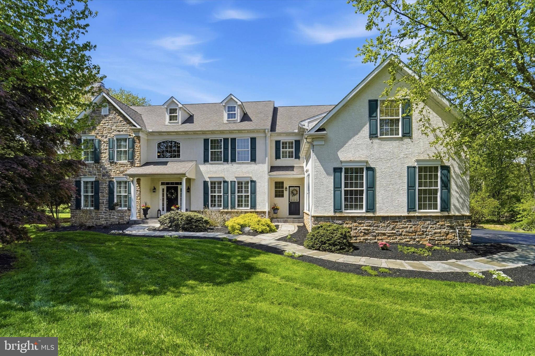 Tucked away on a coveted cul-de-sac in Garnet Valley within the highly rated Garnet Valley School District, 7 Lockhart Drive is an elegant, meticulously maintained residence resting on a premium, private 1.26-acre lot. With four bedrooms and four & a half bathrooms, this home stands out for its added versatility as it also features a large bonus room AND dedicated office - providing exceptional flexibility for guests, work-from-home needs, or extra living space.  The home’s striking exterior, custom walkway, and welcoming front porch set the tone for what awaits inside. Thoughtfully designed hardscaping and lush landscaping elevate the home’s curb appeal, while the property is complemented by the tranquility of surrounding wildlife. Step inside to an expansive foyer, showcasing gorgeous hardwood flooring that extends throughout the entire main level, complemented by plantation shutters and updated lighting. The first floor includes a formal dining room, a sophisticated sitting room with a gas fireplace, and a private office with a closet—ideal for a main-level bedroom if desired. The beautiful kitchen serves as the heart of the home, showcasing granite countertops, an oversized island with seating, gas range, double ovens, built-in desk, soft-close cabinetry, and updated hardware. The kitchen flows into a breakfast area and cozy sunroom - an ideal setting for your morning coffee. Just beyond, a spacious family room anchored by a two-story grand stone gas fireplace adds warmth and charm. Completing this level is a thoughtfully-designed laundry and mudroom with custom cabinetry and direct access to the three-car garage. Upstairs, a cozy window-seat landing creates the perfect nook before leading into the stunning primary suite. This serene retreat features a spacious sitting room, two walk-in closets, and a luxurious bathroom appointed with travertine tile, heated floors, dual vanities, a jetted tub, and rain shower. Down the hall, you’ll find a guest bedroom with an en-suite bathroom, along with two additional generously sized bedrooms and a hall bathroom.  A large bonus room above the garage offers incredible flexibility—ideal as a fifth bedroom, playroom, or home office. A landing overlooking the family room completes the second level. The finished basement is a true showstopper—highlighted by a custom stone-pillared bar set against beautiful stone tile flooring, complete with a wine rack, dual mini-fridges and extra seating. A versatile home-gym, full bathroom and home theater area add to the appeal, while a cozy fireplace creates the perfect setting for entertaining friends or movie-night with family.  Outdoor living is nothing short of exceptional, featuring a Trex deck with custom flared stairs that descend to a beautifully crafted brick paver patio, complete with a built-in fire pit, seating wall and custom lighting. 7 Lockhart Drive offers a private, resort-caliber setting designed for elevated entertaining and refined outdoor living. Not to be overlooked, the expansive backyard is enhanced by an in-ground sprinkler system, mature landscaping, and a rare blend of functional space and natural beauty. Major updates include: dual-zone HVAC (2019), hot water heater (2024), numerous interior upgrades throughout. Offering easy access to major roadways including 202, Rt 1, and I-95, making commuting to Philadelphia, Wilmington, and beyond effortless. Residents will enjoy close proximity to everyday conveniences, upscale dining, and local favorites, as well as beloved community destinations like Booths Corner Farmers Market and nearby parks. Outdoor enthusiasts will appreciate access to scenic trails, open space, and nearby attractions such as Ridley Creek State Park and Longwood Gardens. Garnet Valley is known for its strong sense of community, natural beauty, and top-tier schools—making this an exceptional place to call home. Book your showing today!