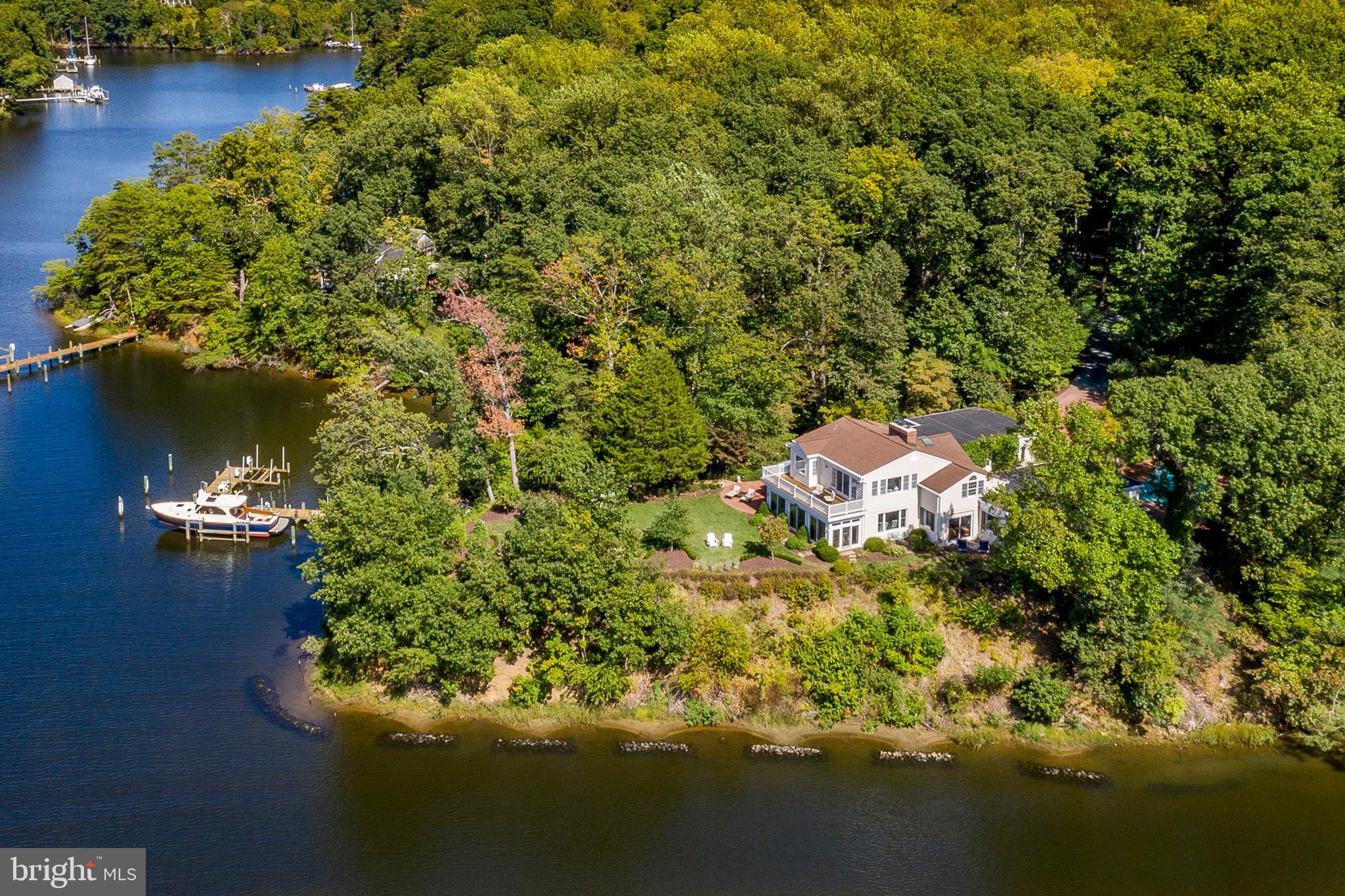 This secluded point of land on Crab Creek and the South River includes a 4-bedroom waterfront home with water views. 594  of deep, protected water frontage, private pier, 2 boatlifts, and pool.  Costal waterfront home features an elegant white kitchen, light filled and open floor plan, hardwood floors, high ceilings,  and moldings. The main level features a 1st floor bedroom, all seasons sun room, family room,  den/library, and a separate dining room that connects to open living room w/FP. Three bedrooms on upper level including master suite.