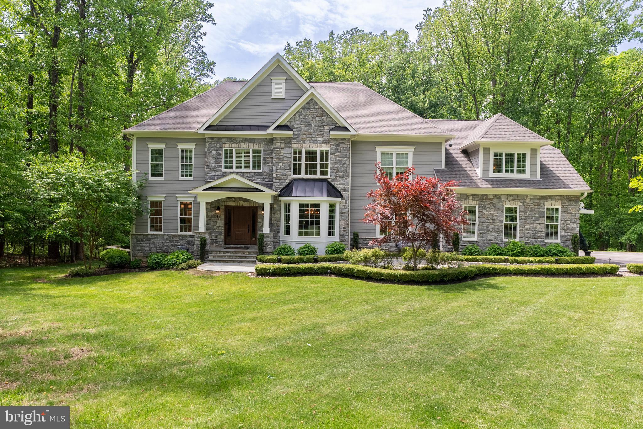 Falls Road Corridor. Prime location. Beautiful 5 bedroom 5 full baths and a half bath on the first floor,  stone and hardy-plank Colonial on 1.98 gorgeous acres.  Grand foyer  with  hardwood flooring and curved staircase.  Family room offers wood flooring , stone wood burning fireplace with beautiful built-ins for entertainment center and wine display with wine cooler.  The Formal dining room is awesome-wood floors as well as beautiful bay window and decorative molding. The beautiful white kitchen with huge 11.5 by 3.5 granite island with prep sink and pendant lighting also offers gas cooking with pot filler over the stove so convenient- farm sink, granite counter tops throughout, hardwood flooring and a tremendous amount of cabinets even in the island with a beverage fridge. Large walk in pantry with built in nugget icemaker, up lit Quartzite counter, and organized shelving.  The guest bath has a pedestal sink and also wood flooring.  First floor laundry/mud room with cubbies just off of the oversized three car garage.  There are three garage door openers, it's heated and newly installed garage tech cabinets. Also on the first floor is a beautiful office with gorgeous built-in desk that has quartzite counter top with shelving, wood floors and decorator window treatments.  Need space for or in-law or guests there is a first floor bedroom with ensuite full bath.   Off of the kitchen  is terrific outdoor living and entertaining. The treks decking with white railings that have cap and down lighting all around offers a covered area that has two tv's, two fans,  heaters and ambient lighting, plus a built in large gas grill that conveys.  When you go down the steps to the beautiful level yard there is a wonderful very kid friendly Amish play set that the children will love.  Plenty of room for soccer, softball, lacrosse practice.  Now upstairs there is an absolutely gorgeous primary suite consisting of a very large primary bath with tile shower with multiple shower heads, a bench and glass surround- there are two sinks on either side of the bathroom with granite counter tops and built-in cabinetry, separated by a bench for storage- There is a soaking tub and plenty of built-ins.  There is even a private beverage area with sink, cabinets and beverage fridge. The water closet has a frosted glass door.  There are three other bedrooms two are connected by an adjoining complete full bath  with a double vanity with granite counter top, and a fourth bedroom has it's own private ensuite bath- You will also find a huge family room  with a walk in closet.  All of the closets are designed by California Closets for maximum storage.  Now for the lower level. First of all it is a walk out lower level to the back yard-there is an exercise room with rubber flooring-and there is plenty of space for entertaining.   The full bath on this level is extraordinary.  The beautiful lighted vanity with marble counter has  pendant lighting, the gorgeous 3 headed tile shower with a Kohler digital shower interface with glass door are only the beginning of what this bath has to offer.  The large utility room houses a utility tub, the holding tank for the whole house sprinkler system, a Novine on demand tankless water heater, purification water system, whole house water booster for great pressure throughout.  Plus a Moen digital water flow smart water shut off that detects water leaks immediately.   Also this home offers a whole house 20K Kohler generator. Other amenities- alarm system, crown molding, self closing drawers and cabinets,  room for a pool and just a beautiful location.