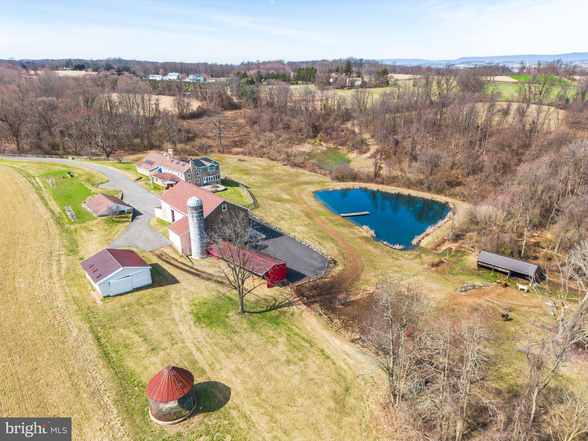 Located on over 94 acres of peaceful farmland within Rockland Township and in the heart of Berks County is the luxurious Widge Farm. This  6,400 sq ft farmhouse features a stunning Great Room with impecable views, marble floors, wood burning fireplace & wet bar. The versatile floorplan  offers 5 bedrooms + 4 bathrooms, including the option of a first floor master suite with massive walk-in-closet adjacent to the home’s kitchen. The jaw dropping indoor pool is an absolute stunner with connected spa, high ceilings, a full bath with shower and additional partial bath. The 2nd floor’s master bedroom suite with en suite bath includes a library area with built in shelves and stunning views of the natural spring. Outdoor amenities include 30 acres of pasture, 30 acres of woodland and 30 acres of tillable farm land, a natural spring, detached 3-car garage and 4,000 square foot barn. Possibilities are truly endless for the amount of open space available. Bonuses include marble floors, original exposed wood beams, exposed stone, 3 fireplaces and a beautiful exterior finished with paver patios & Trex deck. An additional 4.05 acres w/ 1,300 sq foot/ 5 bay garage property is also available for purchase at 99 Fredericksville Road. The total acreage for both properties combined would be 98.5 acres.