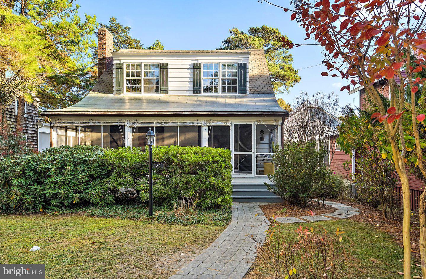 Welcome to 22 Park Avenue, an enchanting "Old Rehoboth" ocean block cottage nestled in the exclusive Pines neighborhood of Rehoboth Beach—an ideal seaside retreat brimming with historic charm and modern conveniences. This delightful property sits on a 50' x 100' parcel, surrounded by mature trees that provide both privacy and tranquility, just steps from the ocean. The heart of this charming home is the spacious screened porch, where you can relax and savor gentle ocean breezes and the soothing sound of waves crashing nearby. Inside, the home exudes coastal elegance with its beamed ceilings, rich hardwood floors, and a wood-burning fireplace – capturing the essence of classic Rehoboth charm. Tasteful renovations bring functionality and convenience to the home, offering everything you need to enjoy easy coastal living. The main house features four spacious bedrooms and two full baths, while the guest cottage provides an additional bedroom and bath, sitting room, and private patio, making this property as versatile as it is charming. With a strong rental history, 22 Park Avenue offers investment potential and an idyllic summer getaway for those seeking the quintessential beach lifestyle. This rare gem combines the historic allure with modern amenities and offers the best of Rehoboth Beach just outside your door. Don’t miss your chance to own a piece of paradise!