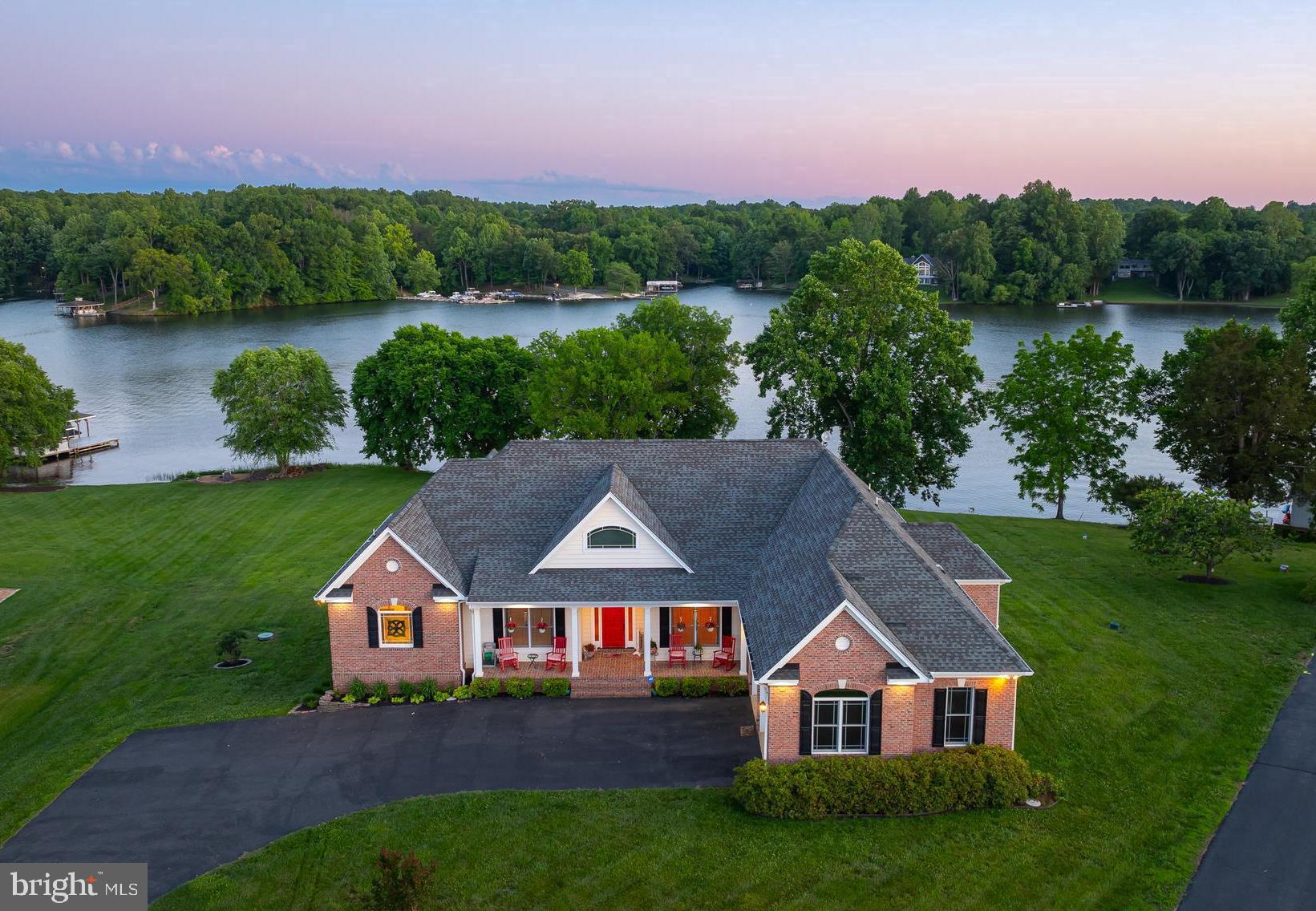 Stunning waterfront masterpiece where luxury meets the serene beauty of Lake Anna's waterfront. This exquisite property offers an unparalleled retreat nestled along the shores of Lake Anna on the public side of the lake with 220 feet of rip-rap shoreline, deep water (12 feet at end of dock) and spectacular views. Truly unrivaled in quality and design, this impeccably crafted escape blends modern luxury living with tranquil lake lifestyle. Encompassing over 5,800+ finished square feet on two open levels, this paradise offers seamless indoor/outdoor lakeside living, with 5 bedrooms, 4.5 baths, and 2 home offices. High speed Comcast Xfinity internet. Main level showcases a massive open great room with 12ft ceilings, gas fireplace with built-in shelving, hardwood flooring and a wall of windows to enjoy the view. The bright breakfast room is open to the gourmet kitchen that supplies stainless appliances and granite countertops. The lakeside primary bedroom ensuite features a sitting area with a gas fireplace, tray ceiling, two walk-in closets, soaking tub and tile shower. a is located on the main level, and en suite primary bathroom with a jetted tub, double vanity & separate tile shower and water closet. Downstairs in the expansive walkout basement, you’ll enjoy the same jaw-dropping water views, a family room, living room, wet bar with a Subzero, rec room, bedrooms, home office, 2 full baths, workshop area and storage room. Designed for both relaxation and entertainment, the outdoor living spaces feature a sprawling deck, patio, and 2 slip boat dock, perfect for enjoying leisurely days by the water or hosting gatherings with friends and family. Whether you prefer soaking in the sun, exploring the lake by boat, or simply savoring the tranquility of waterfront living, this property offers endless opportunities for recreation and rejuvenation. Fox Business named Lake Anna THE TOP “beach” vacation investment location in the entire nation - this lakefront paradise would make an incredibly lucrative investment asset and it comes furnished.