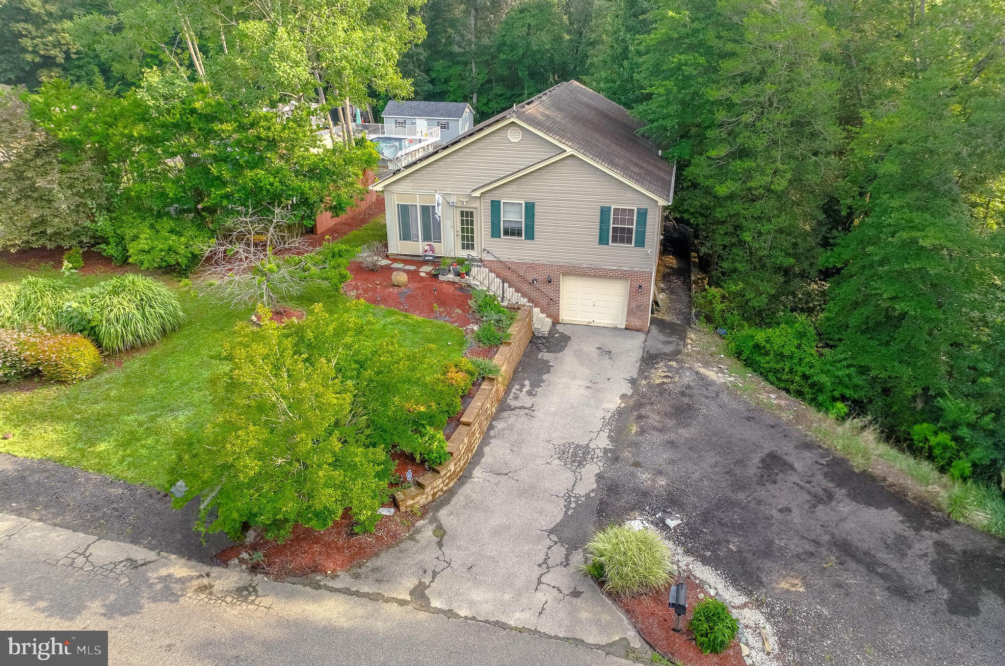 Marvelously Charming Raised Rambler with Entertainment-Ready Backyard and total SQFT of 2,908! Beautifully located on the street with one-way access in a desirable area, this 3BR/3BA residence captures the essence of leisurely living with an oversized 1.04-acre lot, a sparkling above-ground swimming pool, an expansive basement, and a fully-equipped gazebo (fan and electricity). Cheerful and comfortable, the interior captivates with a cozy three-season front porch, an openly flowing layout, high vaulted ceilings, stunning hardwood floors, and a spacious living room with a well-appointed fireplace. As the holidays approach, make cookies and memories in the kitchen, which includes stainless steel appliances, granite counters, white cabinetry, gas stove, built-in microwave, French door refrigerator, dishwasher, recessed lighting, pantry, and a dining area. The large deck is the perfect spot for grilling and chilling overlooking the unbelievable backyard. Explore further to find a firepit, patio, and an over-the-top SHED which comes with air-conditioning, heating, and ventilation! Indoor parties are also a cinch in the huge basement, with plenty of room for media and games. Experience tranquility in the primary bedroom with ample closet space and an upgraded en suite with dual sinks. Other features: 1-car garage, laundry room, no HOA, cost-saving solar panels (new owners take over lease), 5-minutes from Washington D.C. commuter bus, near shopping, restaurants, and schools, and more! Call now to schedule a tour!