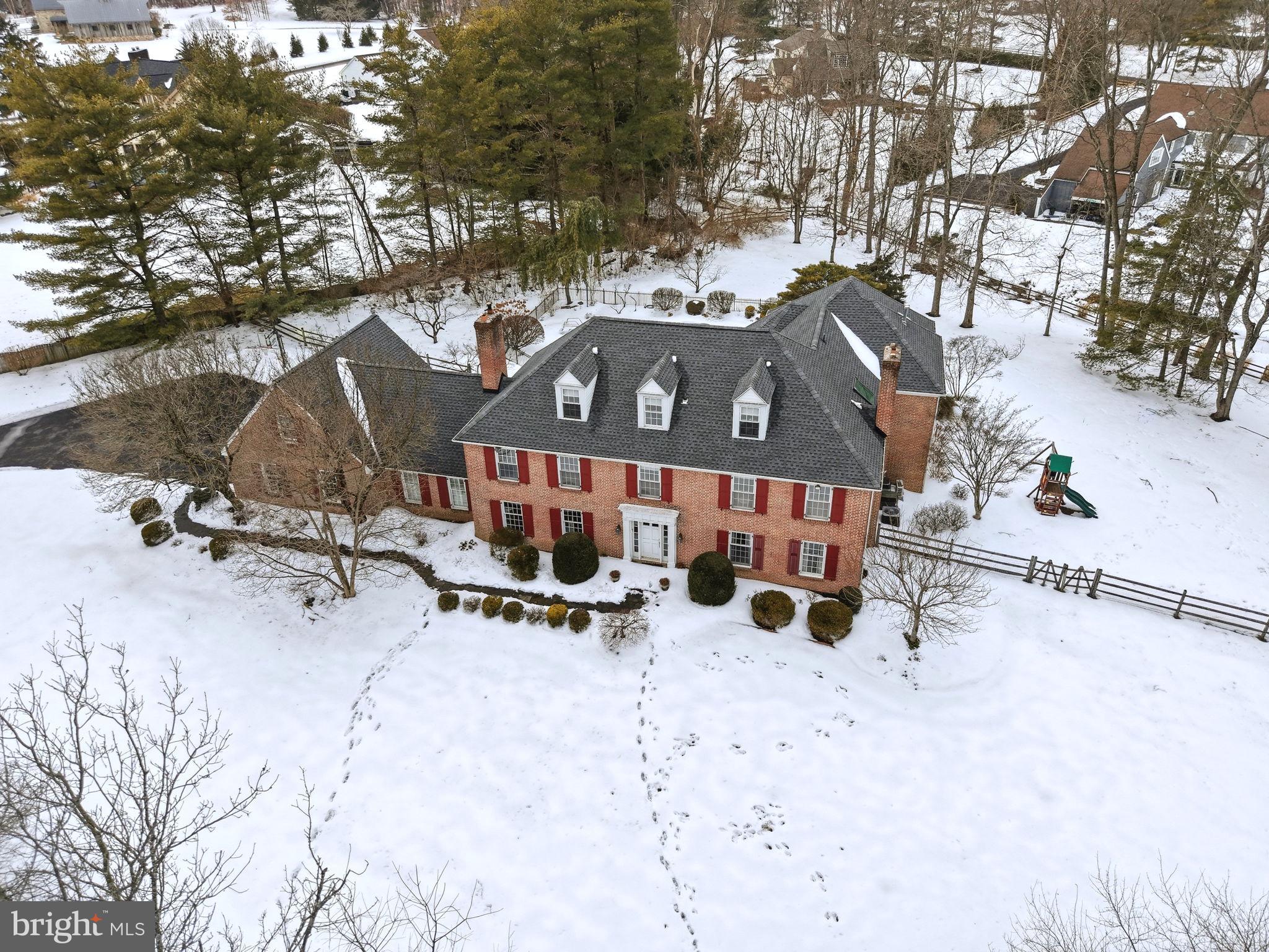Tucked away in an exclusive enclave off Sheaff Lane, this custom-designed brick estate redefines luxury living. With over 6,500 square feet of exquisite interiors on 1.5 acres of lush, manicured grounds, this home is a private retreat where timeless elegance meets modern sophistication.

A long, tree-lined driveway leads you to this serene sanctuary. Inside, rich hardwood floors flow seamlessly throughout the main level, creating a warm and inviting ambiance. The expansive dining room, centered around a wood-burning fireplace with a classic brick surround, invites cozy gatherings, while the nearby office, complete with a built-in desk, opens into a stunning new great room. Flooded with natural light from wall-to-wall windows, the great room features custom built-ins, a gas fireplace with a striking stone surround, and charming window seats. French doors lead to a covered patio, where breathtaking views of the sprawling backyard await.

At the heart of the home is a chef’s dream kitchen, blending style and functionality. Highlights include a grand central island with a 5-burner cooktop, custom Amish-crafted cabinetry, two full-size built-in Sub-Zero refrigerator and freezer units, Viking wall ovens, a Thermador gas cooktop, a Bosch dishwasher, and a stunning oversized copper farm sink. A built-in window seat overlooking the serene landscape is the perfect spot for morning coffee. Adjacent to the kitchen, a cozy sitting area with a wine fridge and dry bar sets the tone for entertaining, while the den, with its wood-burning fireplace and beadboard accents, offers a warm haven for relaxation.

Upstairs, the luxurious primary suite is a peaceful escape, featuring a tray ceiling, a private sitting nook with a gas fireplace, and dual custom walk-in closets. The spa-like ensuite bathroom boasts radiant heated floors, ton of natural lights from the skylight, a Jacuzzi tub, a tiled stall shower, and a double vanity. A second ensuite bedroom and two additional bedrooms with walk-in closets offer ample space, while the upstairs laundry, cleverly integrated into a full bathroom, adds ultimate convenience. A spiral staircase connects the upper level to the great room below, and a finished attic with cathedral ceilings provides endless possibilities for a bonus space or 5th bedroom. The massive basement offers abundant storage or potential for additional living space.

Step outside, and you’ll find your own private oasis. The beautifully landscaped backyard features a sparkling in-ground pool with a brand-new heater and spa pump, offering year-round enjoyment. Multiple covered porches provide the perfect settings for al fresco dining or unwinding with a good book. Whether hosting lively summer gatherings or savoring quiet evenings under the stars, this outdoor space is truly enchanting.

This home is more than a residence—it’s a lifestyle. Every detail has been meticulously crafted to deliver unparalleled comfort, privacy, and efficiency, with six heating zones and four A/C zones ensuring optimal climate control year-round. Perfectly situated in a prime location in Colonial School district, the property offers a rare balance of seclusion and convenience. Just minutes from regional rail, major highways, and the vibrant downtown Ambler area, you’ll have access to an abundance of restaurants, shops, the Wissahickon trails, and Germantown Academy’s expansive campus. Plus, enjoy the benefits of low Whitemarsh Township taxes.

Don’t miss the chance to make this extraordinary property your own. Schedule your private tour today and experience the magic of this spectacular home!