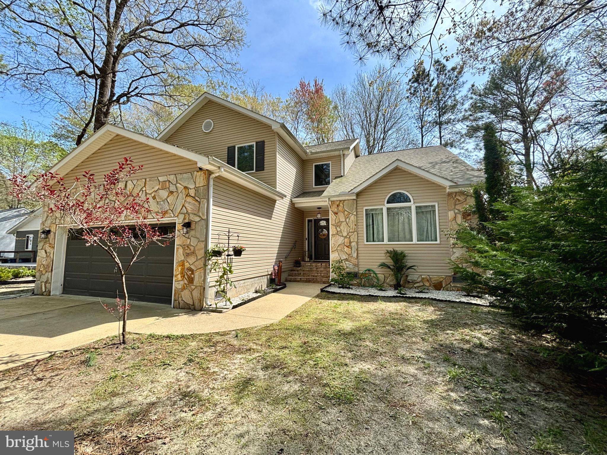 NEW Seller offers $10k towards closing or backyard reno!  This home feels so custom, so grand and ready for you to kick off your shoes and relax. As you walk up you will notice the beautiful stone siding and all the interior upgrades including: the flooring (2022), the designer lighting and coastal cozy details of this home.  You are greeted with a dramatic vaulted ceiling in the living room, complete with gas fireplace making this an entertainer’s dream. The oversized dining room off of the custom kitchen and breakfast area really provides ample space for all your needs. Updated appliances and washer/dryer were added in 2023. With 4 bedrooms, including the primary bedroom on the main floor, plus an additional 2nd floor rec room, you will have a room for everyone to unwind. Check out the attic space! Your 2-car garage is nicely epoxied (2022) and ready for all your beach gear! Updates include a new HVAC in 2026 and crawl space dehumidifier in 2024. At over 3000 square feet, this coastal beauty in South Ocean Pines offers community amenities including several amazing pools, tennis courts, a marina, yacht club, golf course, parks, trails and so much more! This is truly a must see!