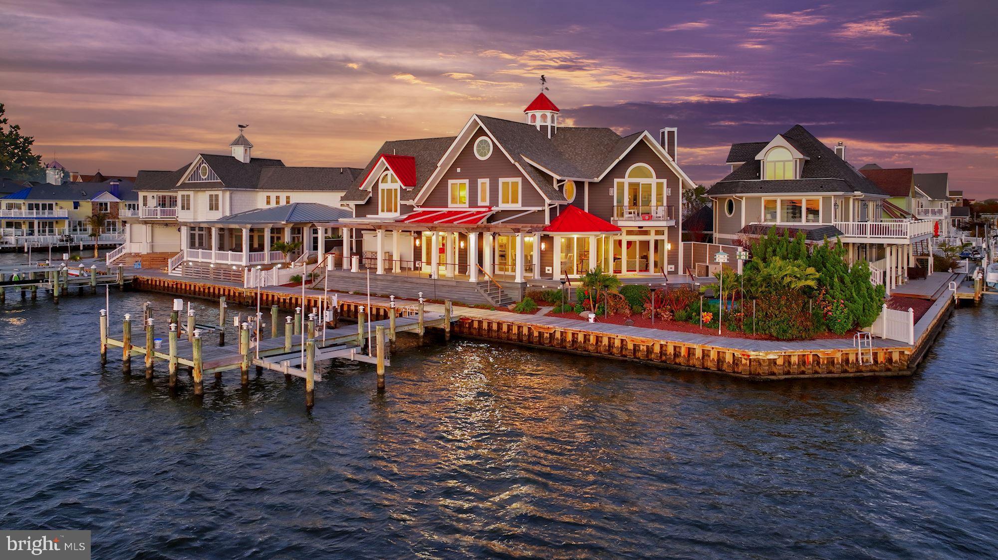 Presenting the finest custom-built waterfront home situated on the finest lot in all of Ocean City. Completely rebuilt with every imaginable amenity needed for gatherings large and small, this is truly an entertainer's paradise Inside you will find an inspiring open-plan design that is wrapped in windows offering spectacular panoramic views. With purposeful design, living, and entertaining options are endless. There are four en-suite bedrooms and five full baths upstairs that allow for options and flexibility. The guest suite can sleep six and the attached bath has two showers. The hall bath is a flex bath to service extra overnight guests sleeping in the guest suite, or in the main level den that can double as a bedroom. The main level is host to a large living room with a central fireplace, large windows, and a slider to access the waterside deck and heated pool which can be set to higher hot tub temperatures and serve as a multi-person hot tub with a feature waterfall. Panoramic water views continue into the banquet-sized dining room with a bay window, slider, and two sidelights from which to take in the views or access the dining deck and heated pool. The entertainer's island and breakfast bar are the perfect transition into the chef's kitchen outfitted with professional stainless appliances that include a six-burner Wolf stove, range hood and pot-filler, Viking fridge, two dishwashers, ice maker, trash compactor, double wall ovens, and a warming drawer. A butler's pantry and wine cooler complete the chef's kitchen Outdoor living is simply stellar and will take full advantage of the spectacular waterside setting, the wrap-around deck offering access to the heated pool, lighted pier, and dock, sided by a high-speed boat lift, and jet-ski lift. Guests will meander from the dock to the pool and sun deck, then to the pergola and adjacent shaded waterside bar to gather for a festive beverage. A full back bar includes three Viking beverage coolers, an ice maker, stainless steel sink, and lighted shelving to provide ambiance for celebrating any occasion. The outdoor bar and half bath with outdoor access can be closed and secured with a remote retractable door when not in season. This is the chance of a lifetime to own the best of the best in Ocean City, Maryland. Come home to coastal living at its finest