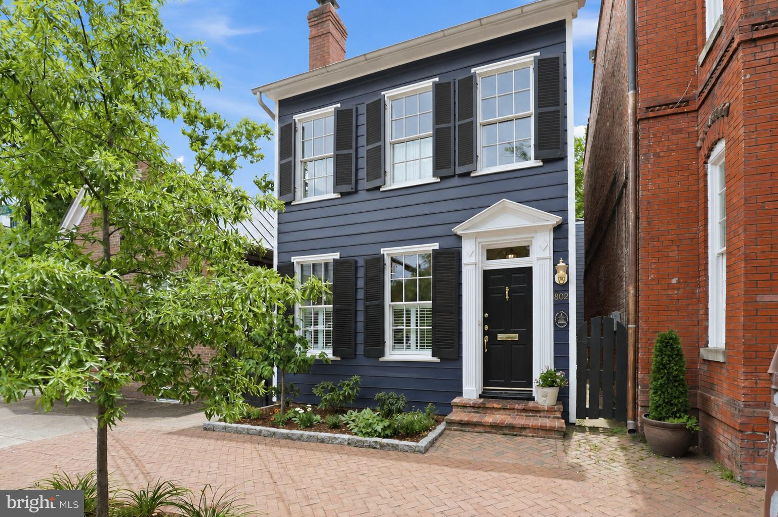 Some homes preserve history. A select few become part of it.

Gracefully positioned along one of Old Town Alexandria's most distinguished streets, this exceptional detached residence has quietly stood as part of the city's architectural story since 1830. Thoughtfully restored and expanded, the home honors its remarkable provenance while embracing a timeless expression of modern living—where historic character and contemporary refinement exist in effortless harmony.

Inside, elegant proportions, rich hardwood flooring, and beautifully curated interiors unfold with quiet sophistication. Gracious formal living and dining rooms transition seamlessly into a thoughtfully designed chef's kitchen before opening to an expansive great room wrapped in walls of glass, where natural light pours inward and everyday living flows effortlessly outdoors.

Beyond, a secluded brick courtyard offers a private sanctuary rarely found in the heart of Old Town. Framed by mature landscaping and accompanied by the gentle sound of a fountain, it becomes an outdoor living room—equally suited for intimate dinners beneath the stars, lively celebrations, or peaceful mornings with coffee.

The upper level is devoted to three generously proportioned bedrooms, including two elegant en-suite retreats. The expansive primary suite evokes the serenity of a boutique hotel, with soaring vaulted ceilings, garden views, dual dressing closets, and a spa-inspired bath designed as a daily escape.

Completing the residence are abundant storage, an insulated and floored attic, and one of Old Town's most coveted luxuries—assigned off-street parking discreetly accessed through a private iron gate.

Moments from the acclaimed restaurants, cafés, boutiques, galleries, waterfront parks, and vibrant charm of King Street, the home offers an extraordinary walkable lifestyle while remaining effortlessly connected to Washington, D.C., Reagan National Airport, the King Street Metro, and Amazon HQ2.

A home to be admired for its history, treasured for its architecture, and remembered for the life lived within it.