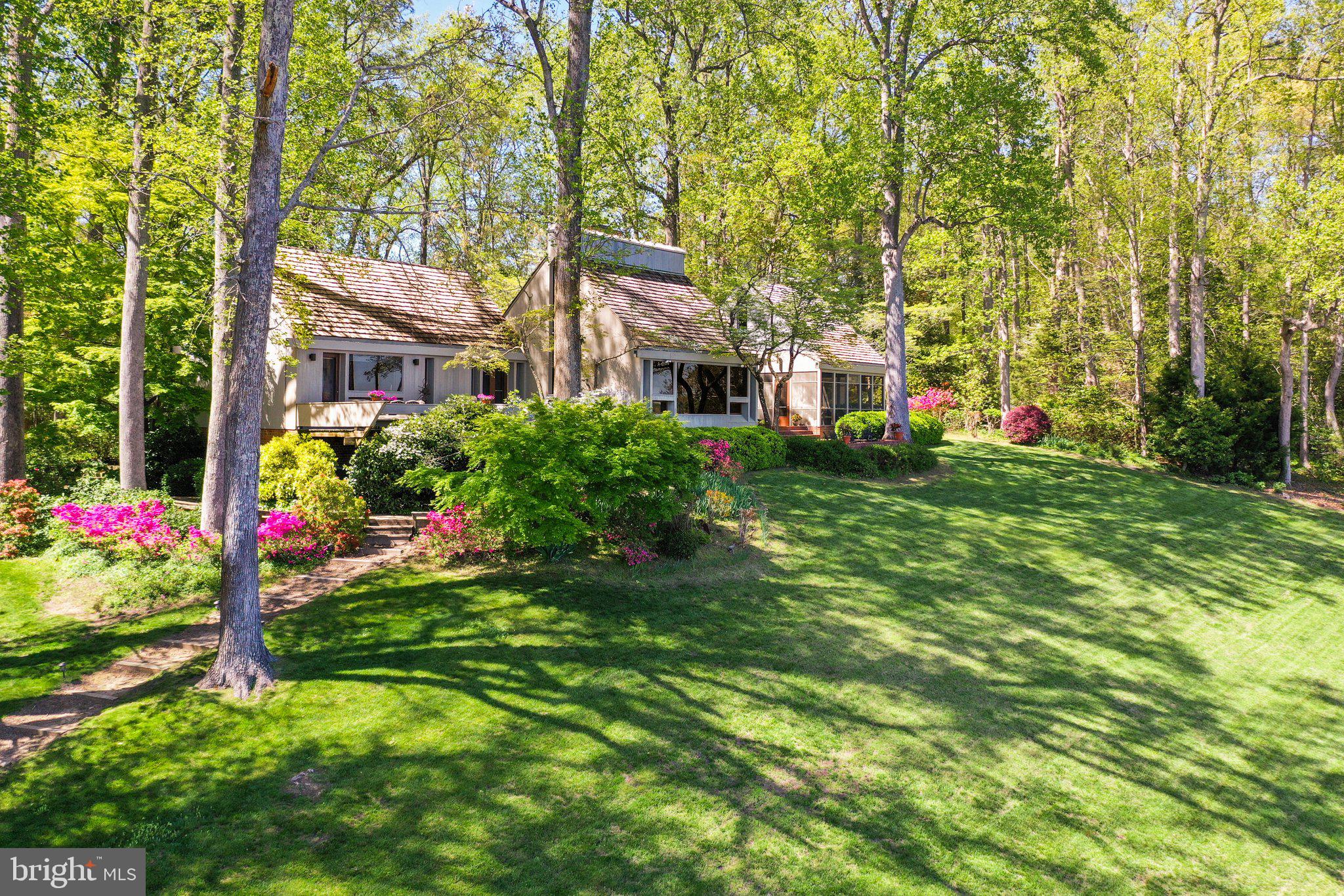 Adjacent waterfront lot available to purchaser for $275,000! Welcome to 1363 Wilton Creek Road, a distinctive waterfront retreat where timeless architecture meets natural elegance, designed in 1975 by architect Bob Borum, inspired by Hugh Newell Jacobson, crafted with rough-sawn redwood siding, a cedar shake roof, and copper gutters. Step through cherry chevron double doors into a great room with soaring vaulted ceilings, exposed rafters, teak flooring from Thailand, and a floor-to-ceiling cupola blending architecture with nature, while picture windows frame panoramic views across the Piankatank River to Stove Point and Gwynn’s Island. Smooth redwood walls, a Buckingham slate foyer, and a gas fireplace add warmth, with a loft offering a whimsical nook for kids. The eat-in kitchen, with concrete countertops aged to a soft patina, is perfectly positioned for river views. The owner’s suite, a sanctuary with a pine-walled den salvaged from Richmond’s Westham Train Station, features river views, a walk-in closet, and an ensuite bath with a frameless glass shower, leading to a screened porch with slate flooring and exposed beams, connecting to a brick patio for outdoor dining. The guest wing includes two bedrooms with a shared Jack-and-Jill bath and a cozy deck with built-in benches for sunrise views or morning coffee. Outdoors, enjoy a private beach, a 324' pier with lighting, a 10,000 lb boat lift, fish cleaning station, 50 amp shore power, swim ladder, a full-size tennis court, and an outdoor shower. Vast majority of furniture and furnishings convey. This one-of-a-kind home offers refined waterfront living with architectural pedigree.