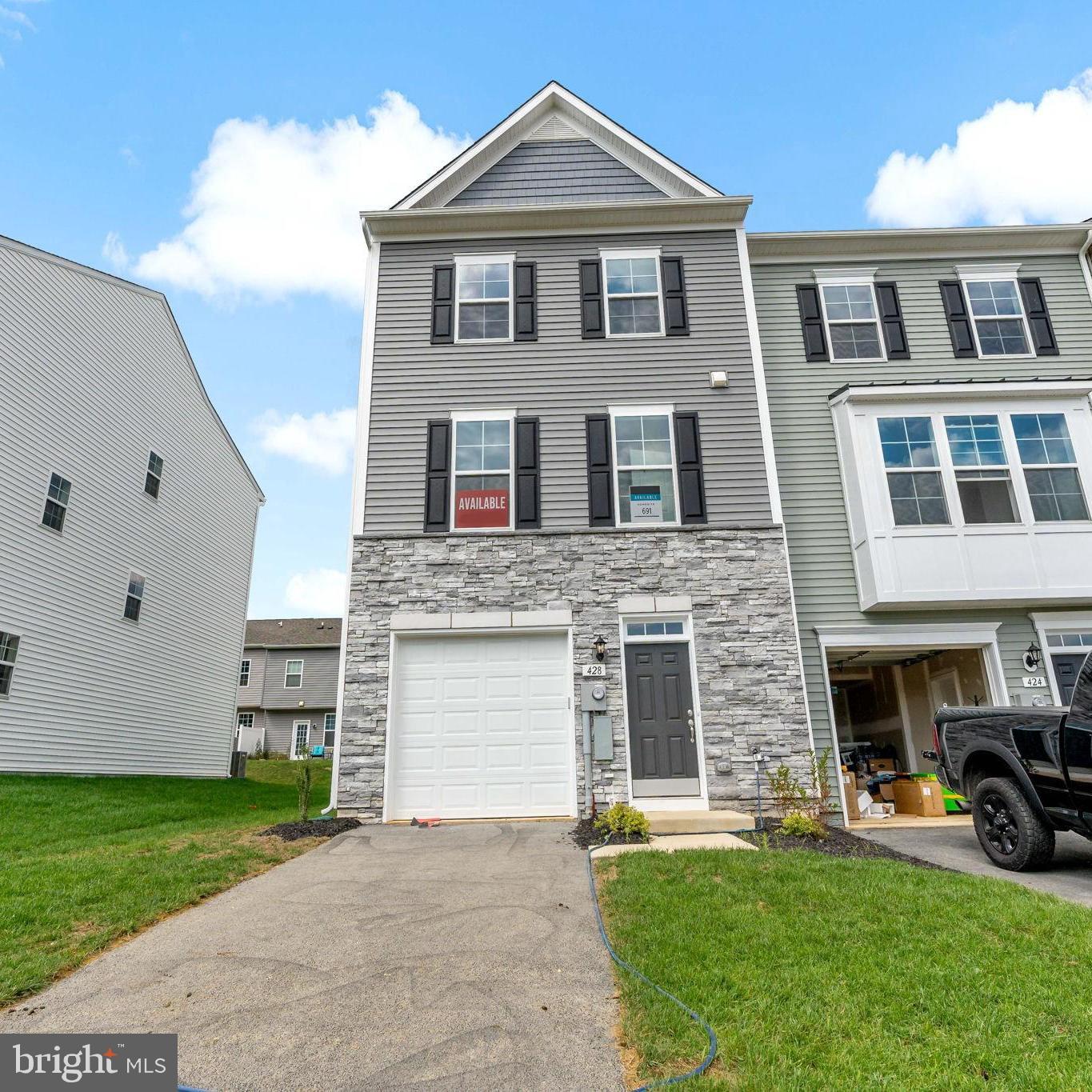 IMMEDIATE DELIVERY conveniently located directly across from the amenity area!
THE ONLY COMMUNITY IN BERKELEY COUNTY, WV WITH NEW CONSTRUCTION AND RESORT LIKE AMENITIES!*NOW OFFERING UP TO $15,000 IN OPTIONS/CLOSING COST ASSISTANCE FOR PRIMARY RESIDENCE WITH USE OF APPROVED LENDER AND TITLE **   CALL SHOWING CONTACT FOR DETAILS.*   
Berkeley County’s premier planned community featuring a clubhouse, swimming pools, walking trails, lush landscaping and mountain views. The Darlington II, 3 level end unit townhome with partial stone front and 1 car garage featuring 3 Bedrooms and 3.5 Baths. The front porch leads directly through the front door into the spacious lower level including 9 ft. ceilings, foyer with a double coat closet, access to the garage continuing into the fully finished lower level recreation room with full bath and walkout access to rear yard with privacy fencing. This home features a 3 level morning room extension. Boxed oak staircase lead you to the open concept main level with 9 ft. ceilings, luxury vinyl plank flooring throughout this level, dining room and kitchen with stainless appliances, large 8’ plus island, upgraded cabinets, quartz countertops, that leads directly into living room with powder room. A second oak staircase leads you to the primary level that features a primary suite that includes a tray ceiling and large walk-in closet. The primary bathroom includes a single vanity with a tiled shower and separate soaking tub. Laundry is located on the bedroom level.