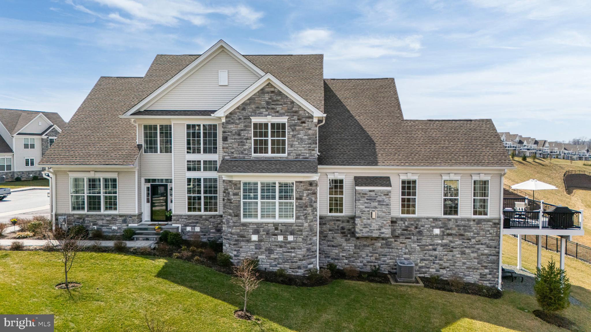 Welcome to 206 Reid Way in the prestigious Darlington Ridge community by Toll Brothers—a newer, upscale, walkable neighborhood offering refined living surrounded by preserved natural beauty.
This exceptional end-unit townhome is a rare, luxurious, fully customized and expanded Bryn Athyn model by Toll Brothers, offering over 4,400 square feet of finished living space, including 3,470 square feet above grade and 1,000 square feet in the finished walk-out lower level—all thoughtfully designed with contemporary finishes and elevated style.
From the moment you arrive, the home’s curb appeal impresses with a covered front porch, slate steps, paver walkway, enhanced landscaping, and elegant gray stone exterior with extended foundation detailing. Inside, a dramatic two-story foyer sets the tone, anchored by a custom turned staircase and wide-plank White Oak engineered flooring that flows throughout all three levels.
Just off the foyer, a private home office (or dining room) features glass French doors and a transom window, creating a bright, sophisticated workspace. The expanded kitchen showcases Century cabinetry in Sherwin Williams Gale Force Gray, custom wood range hood, above and below cabinet lighting, and KitchenAid stainless steel appliances. The oversized center island with pendant lighting, undermount sink, and hands-free faucet is complemented by white Silestone Quartz countertops and backsplash.
The adjacent dining area accommodates large gatherings and is enhanced by an additional window and a custom floor-to-ceiling wall unit (not attached). The open-concept living room features a vaulted ceiling, gas fireplace with custom wood mantle and stone surround, and abundant natural light.
French doors with a transom lead to a spectacular sunroom with vaulted ceiling, stacked stone feature wall, and panoramic views of preserved open space and woodlands. Step outside to the expanded deck and separate balcony with custom and decorative pergola—perfect for entertaining or enjoying sunsets.
The main-level primary suite offers privacy, tray ceiling, large custom walk-in closet, and luxurious ensuite bath with radiant floor heating, stand-alone soaking tub, tiled walk-in shower, and upgraded cabinetry. A mudroom with custom bench sits off the two-car garage, which includes a professionally installed epoxy-coated floor.
Upstairs, a large expanded loft with additional windows provides flexible space for a second family room, study, or home office. Two spacious bedrooms—front and rear—share a well-appointed Jack and Jill bath, with additional storage nearby.
The finished walk-out lower level adds versatility for recreation, fitness, or guest space with possible 3rd full bath, while still offering ample unfinished storage.
Attention to detail includes Sherwin Williams City Loft paint, recessed lighting, custom fixtures, and premium window treatments, including Hunter Douglas plantation shutters, power shades, and 3M UV protection.
Located in the highly regarded West Chester Area School District and served by Bayard Rustin High School, this home is just minutes from West Chester Borough, known for award-winning restaurants, boutique shopping, festivals, and lively year-round events.
A rare opportunity to own a beautifully upgraded, move-in-ready home in one of the area’s most desirable communities—where luxury, convenience, and natural beauty come together seamlessly.