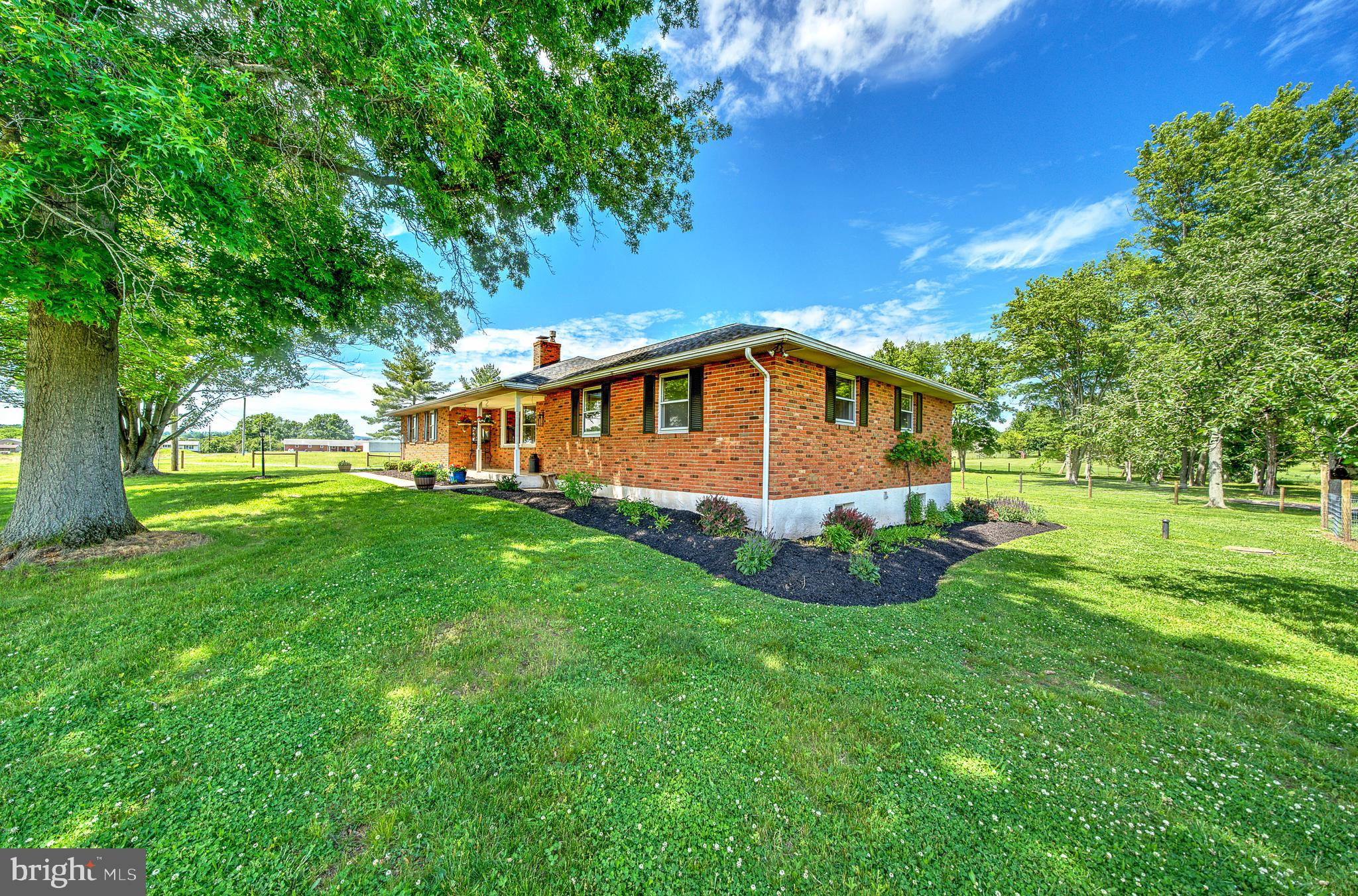 Welcome to your private 10-acre country estate, where rural charm meets comfortable living. This beautifully maintained brick ranch home offers the perfect blend of functionality, recreation, and agricultural opportunity, with the added benefit of potential subdivision opportunities for future investment or development (buyer to perform their own due diligence). Relax on the inviting front porch and take in breathtaking western sunsets, or entertain family and friends on the expansive rear deck overlooking the picturesque property.
Inside, you'll find warm hardwood flooring throughout the main level, a convenient main-floor laundry room, and an updated full bathroom. The inviting living room serves as the heart of the home, featuring a beautiful fireplace that creates a warm and welcoming atmosphere for gatherings and cozy evenings. The well-appointed kitchen showcases elegant granite countertops, stainless steel appliances, and a perfectly positioned window overlooking the backyard, allowing you to enjoy scenic views of the property while preparing meals.
The spacious, fully finished basement expands your living space with a full bathroom and an additional versatile room ideal for a home office, guest suite, gym, hobby room, or whatever suits your lifestyle.
Designed for those seeking the farm-to-table lifestyle, the property is fully fenced and thoughtfully configured with separate pasture sections to accommodate a variety of livestock and farm animals. Two substantial barns provide exceptional versatility. One barn features chicken coops on both ends, allowing you to enjoy the simple pleasure of gathering fresh eggs each morning, while the larger barn offers multiple stalls ready for horses, goats, sheep, or other livestock. A generous garden area provides ample space for growing your own produce, complemented by a charming wooden greenhouse with glass windows, perfect for starting seedlings and extending the growing season.
Adding tremendous value and peace of mind, the residence and one barn received brand-new GAF Timberline® HDZ architectural shingle roofs in September 2025, while the second barn was upgraded with a new metal roof, providing exceptional durability, enhanced curb appeal, and long-term protection throughout the property.
Surrounded by neighboring farms and open countryside, this remarkable property offers privacy, productivity, and panoramic views in every direction. Whether you're seeking a working hobby farm, equestrian property, homestead, or peaceful country retreat, this exceptional estate delivers a rare opportunity to embrace the beauty of rural living—harvesting fresh eggs, cultivating your own garden, enjoying captivating sunsets, and potentially capitalizing on future subdivision possibilities. This is country living at its finest.
