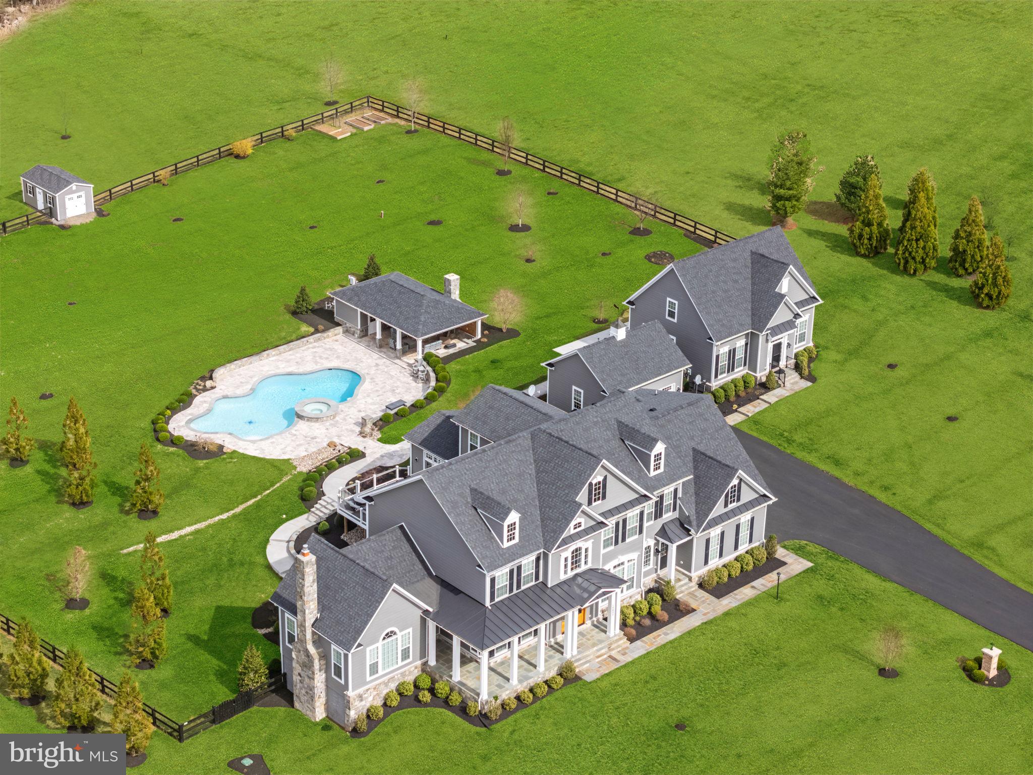 Luxury Living with Stunning Views!

Experience tranquility and breathtaking sunsets, just minutes from downtown Purcellville. This magnificent property, built by Carrington Homes (2018), features TWO HOMES with the finest upgrades and custom details throughout—from hardwood floors to exquisite moldings and elegant archways that seamlessly connect each room.
With over 8,700 square feet of finished space in the main house and an additional 2,500 square feet in the guest house, this estate offers both luxury and comfort. The main house is designed for relaxation and entertainment, featuring multiple gathering areas: enjoy cozy moments by one of the 3 fireplaces, play a round of pool in the basement (pool table conveys), watch a movie in the home theater, or take a leisurely stroll at sunset. The home is spacious yet inviting, perfect for family and friends.  The backyard is fully fenced with 4-board fencing and an invisible fence for your pets.
The owners have spared no expense in enhancing the outdoor living spaces, including a custom inground pool and spa surrounded by stone retaining walls, walkways, and ambient lighting that beautifully connects both homes. The pool is heated for year-round enjoyment, and the covered pool pavilion includes a wood-burning fireplace, built-in grill, ceiling fans, and recessed lighting—perfect for entertaining. A second Jacuzzi spa is located on the lower patio just outside the door.
The main house also offers exceptional storage and parking with a 4-car garage, while a 2-car detached garage provides additional space for vehicles, storage, or a workshop.
The charming 3-level guest house offers 2 bedrooms, 2 ½ baths, a full kitchen, laundry, and a fireplace. With its own private deck, separate utility hookups, and dedicated electric meter and FiOS connection, this guest house is an ideal space for in-laws or guests. 
If you’re seeking a peaceful and spacious retreat with proximity to all the conveniences of town, don’t miss the opportunity to tour this exceptional property. Contact your Realtor today for a private showing.