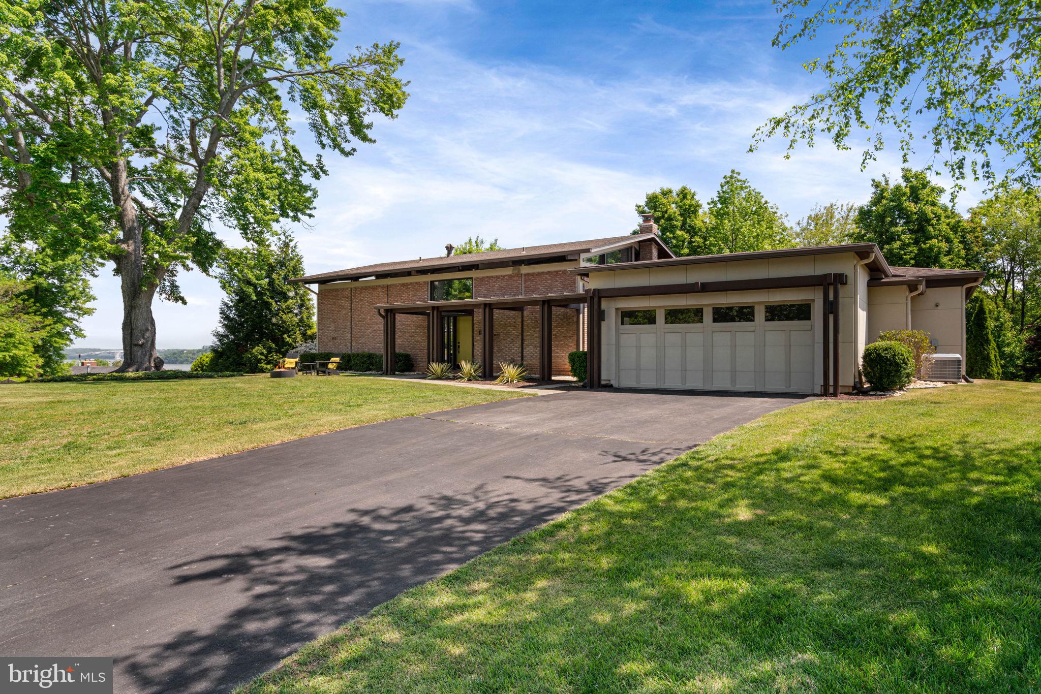 **Offer deadline: Tuesday  May 5th 6:00 pm**  Villamay's most architecturally significant home, designed and originally owned by William "Bill" Vosbeck, FAIA, whose firm earned more than 60 design awards across the Mid-Atlantic. It sits on a quiet cul-de-sac with sweeping, year-round views of the Potomac River and two cantilevered decks that extend into the surrounding tree canopy.

The interiors were comprehensively renovated in 2023 and are unified by a soft, gallery-white palette, rimless recessed lighting, and Artemide and Sonneman fixtures throughout.

The main living area centers around an L-shaped wall of windows oriented toward the Potomac, with twelve-foot ceilings and a wood-burning fireplace. Eastern light fills the space, with National Harbor visible in the distance.

The kitchen sits just beyond, with clean lines, integrated appliances, large island with breakfast bar and a bold blue tile backsplash that anchors the room.

A separate room nearby works well as an office, lounge, or guest room.  The attached powder room finished in Porcelanosa terrazzo-look tile with Sonneman fixtures adds a more playful note.

On the lower level, the primary suite offers a quiet retreat, with a custom walk-in closet, a Porcelanosa bath, and sliding doors that open directly to the slate patio. Two additional bedrooms share a bath with the same finish quality.

A connected addition creates a private suite with its own living area centered around a gas fireplace and wet bar, along with a large bedroom, walk-in closet, and full bath. With direct access to the deck and river views beyond, the space works well for extended family, guests, or an au pair while still feeling integrated with the main home.

All this sprawling across a lush nearly half acre lot. The grounds feel established and natural, with mature plantings that have grown into the landscape over time.
**Contact agent for extensive list of recent updates**