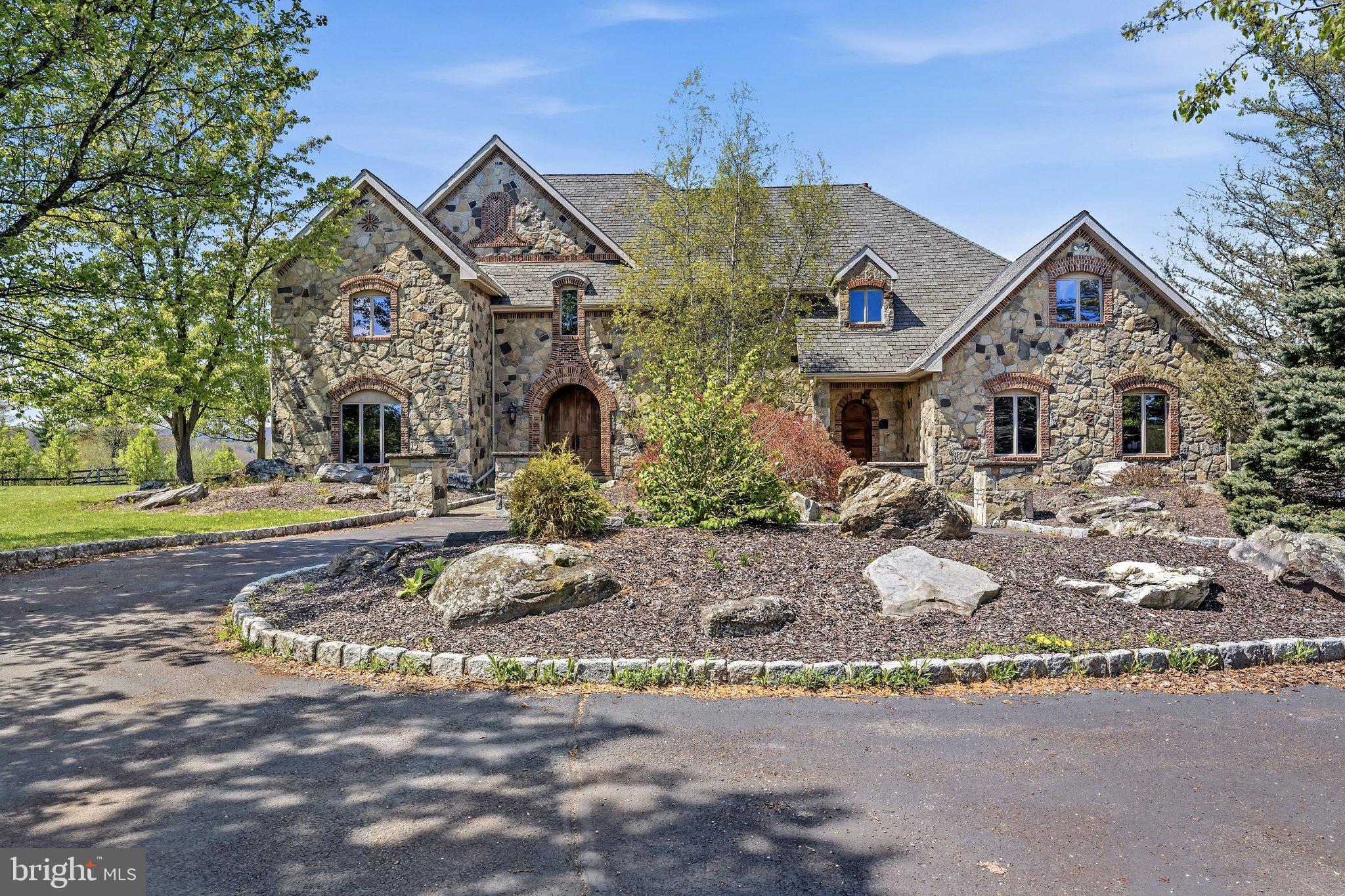 Behind a winding 2,400-foot paved drive, 72 acres of rolling countryside unfold into one of the most distinctive private estates in the Poconos. The approach alone sets the tone - a gradual transition from the outside world into a landscape defined by open pasture, mature woodland, and panoramic views that stretch uninterrupted across the horizon. The setting feels expansive, private, and remarkably self-contained.

Pohopoco Creek winds naturally through the acreage, shaping a distinct ecological corridor of mature riparian trees, native wildlife, and seasonal movement. The presence of water introduces environmental depth rarely found at this scale - enhancing privacy, biodiversity, and long-term land value while creating a setting that feels both protected and alive.

At the heart of the estate stands a 6,400 square foot French-inspired stone residence designed with structural integrity and architectural permanence in mind. Full masonry stone construction, exposed timber trusses, arched architectural openings, and a soaring two-story great room establish immediate presence. A dramatic floor-to-ceiling masonry fireplace anchors the main living space, while slate and hardwood flooring, artisan millwork, and solid wood trim reflect craftsmanship over trend.

The kitchen was designed for scale and gathering, featuring generous prep areas, professional-grade appliances, and open sightlines to the surrounding living spaces. It is equally suited for intimate family dinners or large-scale entertaining. The private primary suite offers balcony access overlooking the acreage, creating a quiet retreat within the estate. Multiple living areas, including formal and informal gathering spaces, provide flexibility for hosting, work-from-home needs, or multi-generational living.

Beyond the residence, the land continues to deliver. Established barns, paddocks, fencing, and agricultural infrastructure support equestrian or boutique farming pursuits. Currently home to a successful alpaca operation, the property demonstrates proven livestock capability while maintaining its luxury estate presence. The acreage offers a rare combination of usable pasture and natural woodland, allowing for both productive agricultural use and conservation-oriented enjoyment.

The grounds also feature an in-ground pool positioned to take advantage of the surrounding views, a four-car attached garage with generous bay depth, and extensive paved access throughout the property.

This is not simply acreage paired with a home. It is a privately positioned legacy estate where land, water, architecture, and infrastructure align. Opportunities offering this level of scale, environmental diversity, and structural quality rarely become available in the region.

For those who value autonomy, land ownership, and enduring construction over trend-driven living, 216 Merwinsburg Road represents a generational acquisition.