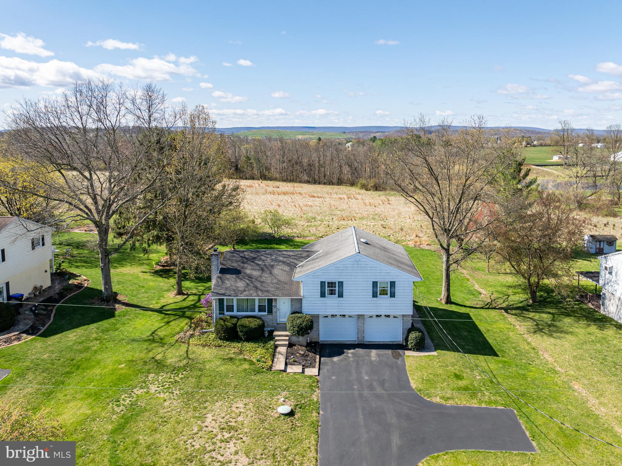 This well-maintained split level located in a peaceful country setting.  The home has been lovingly cared for over the years and is ready for you to add your personal touches to truly make it your own!  Step inside to the living room with an expansive picture window that fills the space with lots of natural light.  The layout seamlessly connects the kitchen and dining room, perfect for everyday living and entertaining.  The kitchen features plenty of cabinets and stainless-steel range and refrigerator.  There are three generously sized bedrooms, including the primary bedroom with powder room.  The hall bath is spacious and has a built-in vanity and laundry area with a washer and dryer included.  The lower level has a large family room with a charming beamed ceiling and a wood-burning brick fireplace, an ideal space to relax or gather with family.  An Additional room in the lower level offers great potential as a workshop, craft room, or gym.  The home has a water treatment system and central air.  The oversized two car attached oversized garage offers plenty of space for your vehicles and your tools.  Outback, enjoy the large, flat backyard for gardening or play.  This great home is located in a quiet neighborhood!  Don’t miss out!!