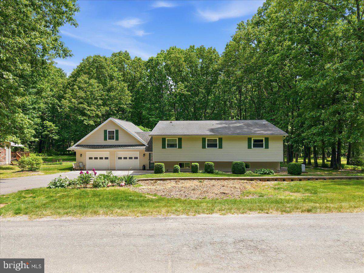 Welcome to this one-of-a-kind contemporary split-level home that perfectly blends modern design with everyday comfort. From the moment you step inside, you'll be impressed by the soaring vaulted ceilings, open-concept floor plan, and abundance of natural light. The beautifully updated kitchen is a chef's dream, featuring granite countertops, double ovens, ample cabinetry, and seamless flow into the main living and dining areas. Rich Brazilian cherry hardwood floors and a cozy pellet stove add warmth and character throughout the main living space. The second level offers three spacious bedrooms and two full bathrooms, including a stunning primary suite with an updated spa-like bath featuring a walk-in shower. The finished lower level provides exceptional flexibility with a large recreation room, additional bedroom, walk-out entrance, and lift accessibility—making it an ideal setup for an in-law suite, multi-generational living, or private guest quarters. Need even more space? The expansive bonus great room above the attached heated two-car garage offers endless possibilities for a home office, gym, media room, playroom, or hobby space. Step outside and enjoy summer days cooling off in the inground pool, all while enjoying the privacy and tranquility of this desirable Mahoning Township neighborhood. Conveniently located just minutes from grocery stores, restaurants, shopping, Mauch Chunk Lake, the D&L Trail, and major commuter routes, this home offers the perfect balance of peaceful living and accessibility. This turnkey showstopper is truly unlike anything else on the market. Schedule your private showing today before this exceptional property is gone!