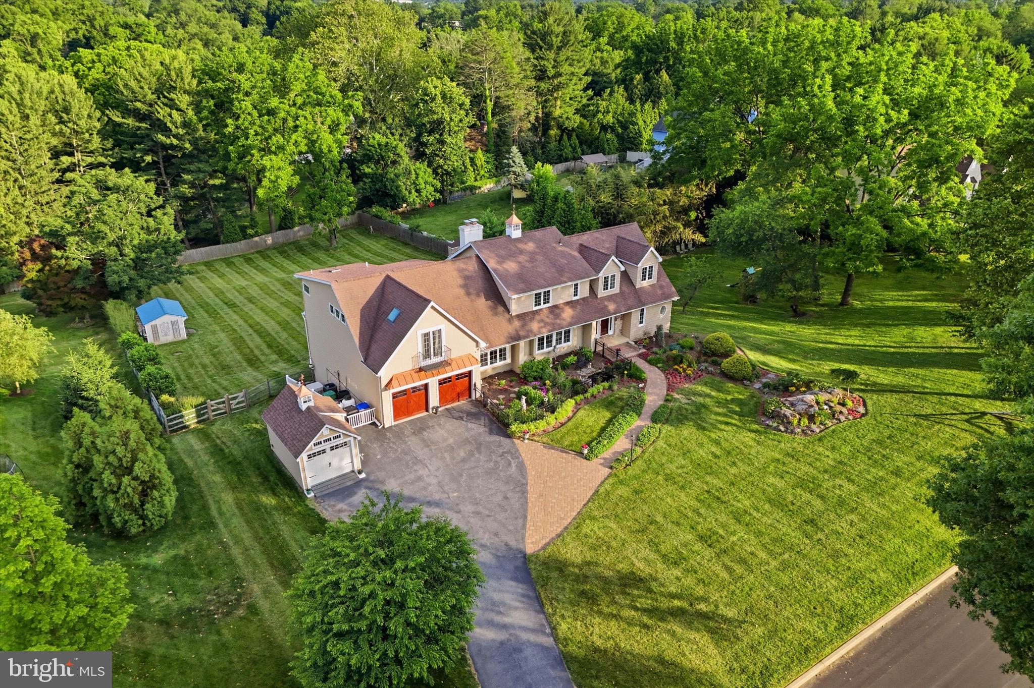Tucked within one of the most admired neighborhoods in Marple Newtown School District, 5 Sugar Maple Drive is a private, resort-inspired residence offering 4 bedrooms, 4.5 bathrooms, a dedicated home office, a fully finished walkout lower level with bonus 5th bedroom/office, & a rare main-level primary suite, where sophisticated, sun-drenched interiors and breathtaking outdoor living exist in perfect harmony. Originally built in 1984 & comprehensively reimagined through a substantial renovation & expansion in 2012, this exceptional home offers a level of warmth, scale, & refinement that feels both elevated and inviting. Equally impressive is the stewardship behind the scenes, including dual HVAC systems installed in 2023, all windows & exterior doors replaced within the last two years, a whole-house generator, & architectural details such as mahogany garage doors, a copper-clad portico, & a striking copper cupola that contribute to the home's timeless presence.
The main level is designed to balance grand entertaining with effortless everyday living. At its heart is a beautifully updated white kitchen featuring brand-new cabinetry, dual sinks, a breakfast bar, generous dining space, & an expansive pantry & mudroom with laundry, conveniently located just off the attached two-car garage. The kitchen opens seamlessly to the dramatic family room, where soaring cathedral ceilings, abundant natural light, & walls of glass create an inviting gathering space. Sliding doors lead to a sprawling multi-tiered deck overlooking the remarkable backyard beyond. A gracious formal living room & dining room provide elegant spaces for hosting, while a dedicated first-floor home office offers privacy and functionality. Completing the main level is the rare primary retreat, offering a luxurious bedroom, spa-inspired bath, & exceptional flexibility for multigenerational living, long-term convenience, or sophisticated guest accommodations. 
Upstairs, two spacious secondary bedrooms share a well-appointed full bath, while the expansive upper-level primary suite serves as a private sanctuary. Featuring two closets, a sitting room, & a dramatic overlook to the living spaces below, the suite combines privacy, scale, & architectural character to create an extraordinary owner's retreat.
The fully finished walkout lower level introduces yet another layer of living space, designed for recreation, wellness, & entertaining. It features a dedicated exercise area, pool table space, bar, expansive gathering areas, & a fifth bedroom ideal for an au pair, guest suite, office, or bonus room. With direct access to the backyard and pool area, the lower level lives as a true extension of the home.
Outside, the property transforms into a destination all its own. Anchored by the in-ground pool added in 2014 & framed by mature landscaping, the rear grounds offer a remarkable sense of privacy and tranquility. Whether hosting summer celebrations, enjoying an evening by the water, or gathering with friends on the expansive deck, the outdoor living experience rivals that of a boutique resort. An additional detached garage space provides the perfect setting for a workshop, collector vehicle, or hobby space.
Perfectly positioned along the Main Line's desirable western corridor, the property is located less than half a mile from Aronimink Golf Club, under two miles from Episcopal Academy, & less than three miles from Chanticleer, Academy of Notre Dame, & Overbrook Golf Club. Just minutes away, Ellis Preserve offers an exceptional collection of dining, shopping, & wellness destinations including Whole Foods, Ruth's Chris Steak House, Sedona Taphouse, First Watch, LaScala's, Club Pilates, & more.
Rarely does a home offer such a compelling combination of thoughtful renovations, exceptional amenities, architectural character, & one of the area's most coveted locations. 5 Sugar Maple is a residence designed not only to be admired, but to be truly lived in & enjoyed for years to come.