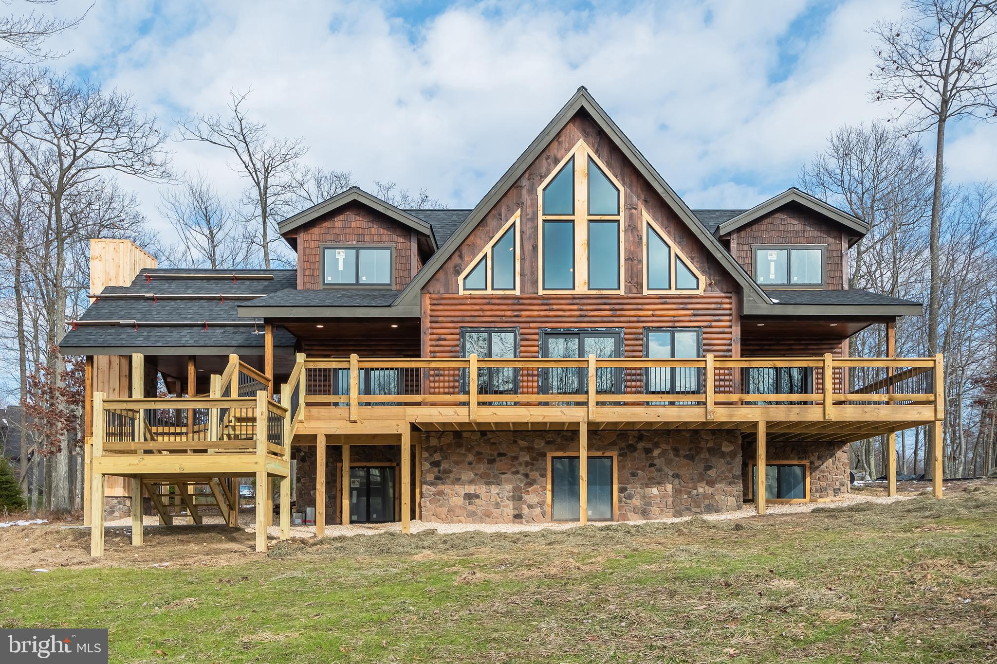 Stunning, almost new Mountaineer Log Home situated just steps from Lodestone Golf Course with filtered lake views! Recently painted throughout, this home has it all. Plenty of space, wonderful location and mountain views that go on forever. This home offers six en-suites, each boasting very nice private baths. Three levels of living space which includes a lower family room featuring a stone fireplace and wet bar.  The main level catches your eye from the moment you enter the door with plenty of large windows and doors allowing the beautiful outside in. The kitchen and dining area are well thought out for entertaining family and friends. The kitchen has been totally renovated to include all new cabinetry, high end appliances, wine cooler, built-in microwave, ice maker and 48" range w/double ovens. If the inside doesn't take your breath away, just step outside to the large deck and enjoy the views from all directions. The deck offers a covered space featuring an impressive stone fireplace. The home also includes beautiful French doors downstairs making it very easy to access the large hot tub, perfect to enjoy during any season. The location of this home is in the heart of Deep Creek Lake, just minutes to Wisp Ski Resort and Deep Creek Lake.
