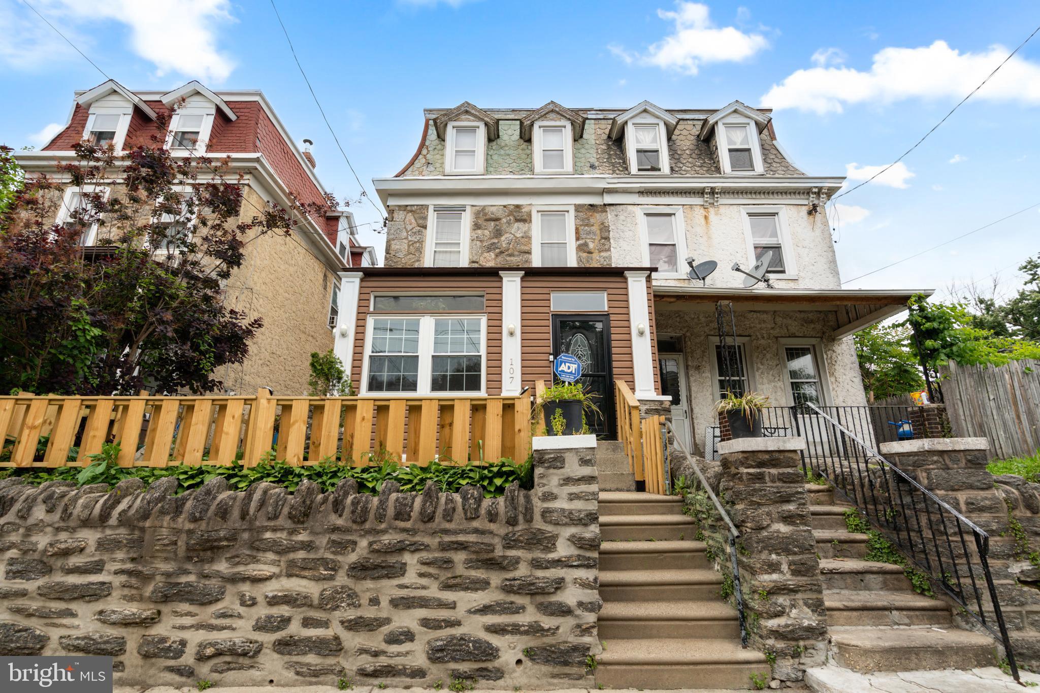 Germantown’s architectural history comes alive at 107 W. Seymour Street — a stunning Second Empire-style residence that has been thoughtfully and meticulously restored from the ground up. With a striking stone façade, brand new roof, and over 2,295 square feet of beautifully finished living space across three floors, this 6-bedroom, 2.5-bathroom home is one of the most compelling values in all of Northwest Philadelphia.

Come inside to a grand enclosed front porch featuring soaring cathedral ceilings, new bay windows, ceramic tile flooring, and a gorgeous exposed 12-foot stone wall warmed by an electric fireplace — a true showstopper before you even step inside. From there, a welcoming foyer greets you with a dedicated coat area and brand new custom hardwood flooring that flows seamlessly through the entire first floor.

The sun-drenched living room commands attention with 12-foot ceilings, a tiled gas fireplace, custom built-in bookcases, a 70-inch ceiling fan, and modern lighting — all anchored by stunning new hardwood floors and a beautifully preserved original stained staircase that speaks to the craftsmanship of a bygone era.

The open-concept kitchen is a chef’s dream — outfitted with custom cabinetry with interior lighting, stainless steel appliances, a wraparound beverage center, custom butcher block countertops, under-cabinet lighting, ceiling fans, and recessed lighting throughout. Whether you’re meal prepping or entertaining, this kitchen delivers on every level.

Tucked at the rear of the first floor is a brand new addition housing a dedicated laundry room and stylish powder room, highlighted by an exposed original brick wall that adds warmth and character. Front-load washer and dryer are included, and high-quality vinyl flooring, a new window, and new doors complete this thoughtfully designed space. Step outside to a large backyard featuring new lighting, and a custom-built privacy fence with solar lighting that runs from the backyard all the way to the front of the home — perfect for outdoor entertaining or simply unwinding after a long day.

Upstairs, six generously sized bedrooms are outfitted with brand new carpet throughout, offering a fresh, move-in ready feel. The partially finished basement adds even more versatility — ideal as a media room, home gym, or additional storage.

Located in the heart of historic Germantown, you’re steps from SEPTA regional rail and bus lines, minutes from Chestnut Hill’s boutique shops and restaurants, and with easy access to Routes 1 and 76 for a smooth commute throughout the city and surrounding counties. With low annual taxes of just $3,414, this is an extraordinary opportunity to own a turnkey, character-rich home at an unbeatable price point.

Schedule your private showing today before someone else makes it home.