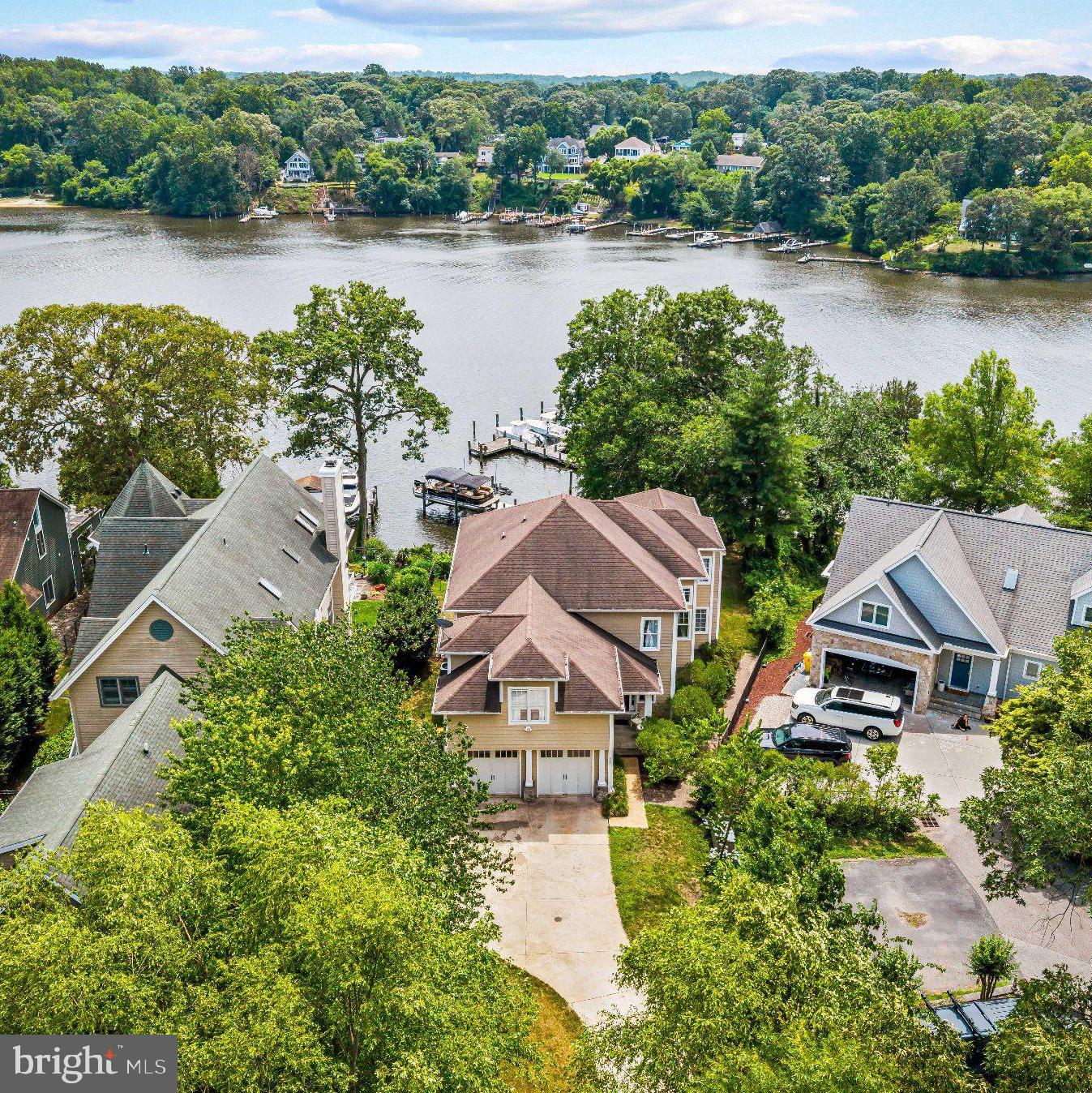Experience exceptional Severn River waterfront living in this custom-built home that truly checks every box. Perfectly positioned on a private half acre with 45 feet of shoreline, this extraordinary property captures breathtaking panoramic water views from three levels while offering the ideal blend of luxury, comfort, and an unmatched waterfront lifestyle.

Designed for entertaining and everyday waterfront living, the outdoor spaces are equally impressive. The property offers usable yard space both at the top of the property and along the waterfront, providing plenty of room for recreation, gatherings, and outdoor enjoyment. A screened porch with heater, expansive waterfront deck with a retractable awning, private beach, and deep-water dock equipped with a 13,000-pound boat lift with remote, two personal watercraft lifts, electric, dock lighting, outdoor shower, and freshwater create the ultimate setting for boating, entertaining, and relaxing on the Severn River with direct access to the Chesapeake Bay.

At the heart of the home is a chef's dream kitchen featuring professional-grade appliances, a six-burner cooktop, two sinks, two dishwashers, double wall oven, convection microwave, expansive breakfast bar with seating for eight or more, an eat-in breakfast nook, walk-in pantry, and a butler's pantry complete with a wine refrigerator and wet bar. The kitchen flows seamlessly into the impressive great room with a gas fireplace and spectacular water views, while the formal dining room with a tray ceiling provides an elegant space for entertaining. Additional main-level features include a welcoming front porch, custom inset hallway lighting, a spacious laundry room, a half bath, beautiful hardwood flooring throughout, and extensive custom crown molding and millwork.  Thoughtful touches like pull out spice shelves next to the stove, touch feature faucets, countertop glass rinser, undermount lighting, and additional storage in the breakfast nook seat sets this home apart from others.

The luxurious waterfront primary suite is a private retreat featuring a gas fireplace, sitting area, spa-inspired bath with a jetted soaking tub, oversized steam shower, dual shower heads, 6 sprayers, dual vanities, and walk-in closet, plus an impressive 14' x 11' dressing room with an additional shoe closet. The upper level also features a second bedroom with a private ensuite bath, a third bedroom with a jack and jill bath, and a fourth bedroom all with large closets. 

The finished walkout lower level expands the living space with a large recreation room featuring a custom bar, theater room, fifth bedroom, full bath, and abundant storage. The homes interior and exterior are fully wired with surround sound smart features making this home your Summer dream! All TVs, surround sound, and theater room equipment in the home will convey.

From its thoughtfully designed interior to its exceptional outdoor amenities, private dock, and breathtaking waterfront setting, every detail of this remarkable residence has been carefully crafted to maximize everyday living and unforgettable entertaining on the Severn River.