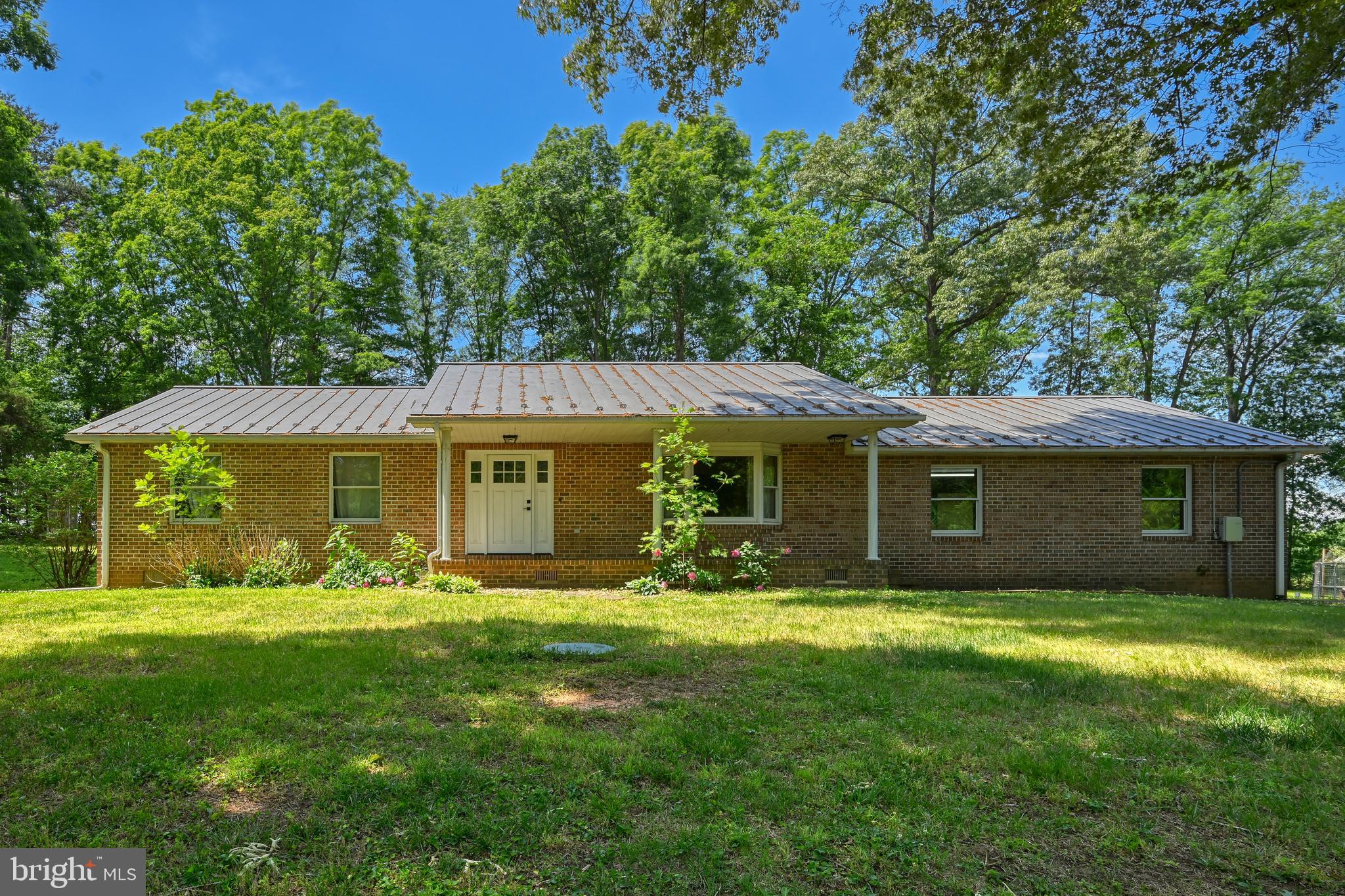 Welcome to country living at its finest! Bring your horses, goats, chickens, dogs, and all your farm animals to enjoy this beautiful 13+ acre property loaded with amenities. The property features a stocked pond for fishing, horse stable, riding ring, barn with paddocks, and electric fencing already in place. A separate detached garage provides plenty of room for vehicles and equipment, plus a unique indoor climbing wall for both kids and adults to enjoy.
The charming brick rancher overlooks the pond, offering peaceful views from the front porch where you can relax and watch the wildlife or your animals roam. Inside, the home offers 3 bedrooms, 2 full bathrooms, and an office/den that could easily serve as a 4th bedroom, complete with sliding barn doors and scenic pond views. Hardwood floors run throughout, while the open kitchen and living area create the perfect space for entertaining.
Additional features include newer HVAC, solar panels for extremely low energy costs, generator backup capability during power outages, RV hookup, and a wood stove in the attached garage. Conveniently located and packed with possibilities, this one-of-a-kind property truly has it all. Don’t miss your chance to call it home!