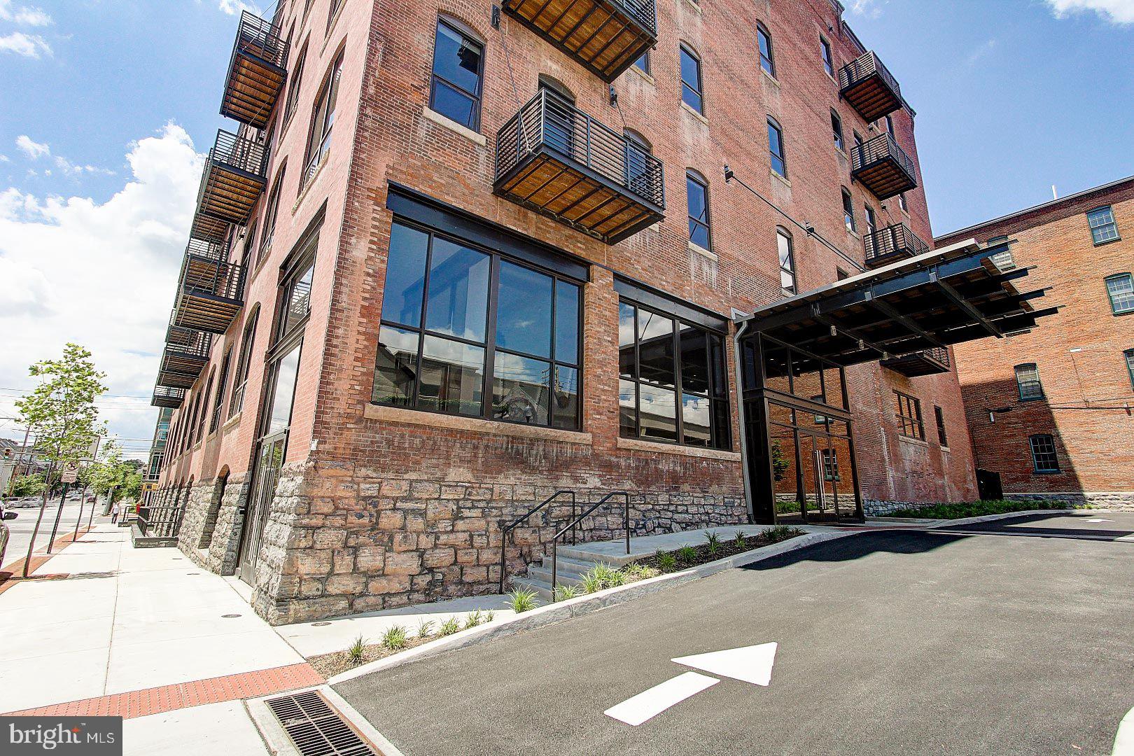 Beautiful 5th floor 2 bedroom, 2 bath condo in the historic Lancaster Press Building! Open floor plan with high ceilings, exposed brick walls & concrete columns. Kitchen features granite countertops, island, tile backsplash, under cabinet lighting and stainless appliances including gas range, refrigerator & dishwasher!  Hardwood flooring in foyer, kitchen and living room. Primary bath features shower with tile base & surround, glass shower door and tile floor. Stackable front loading washer & dryer. Relaxing rear balcony. Unit includes assigned parking space in secure & lighted adjoining parking garage on N. Market Street, and an assigned  storage unit in ground level. Monthly $300.00 condo fee included assigned parking, water, sewer, trash, gas for cooking, use of roof top deck & onside fitness center 24/7, and common area maintenance. Pet Friendly Building. EZ to show - quick possession possible!