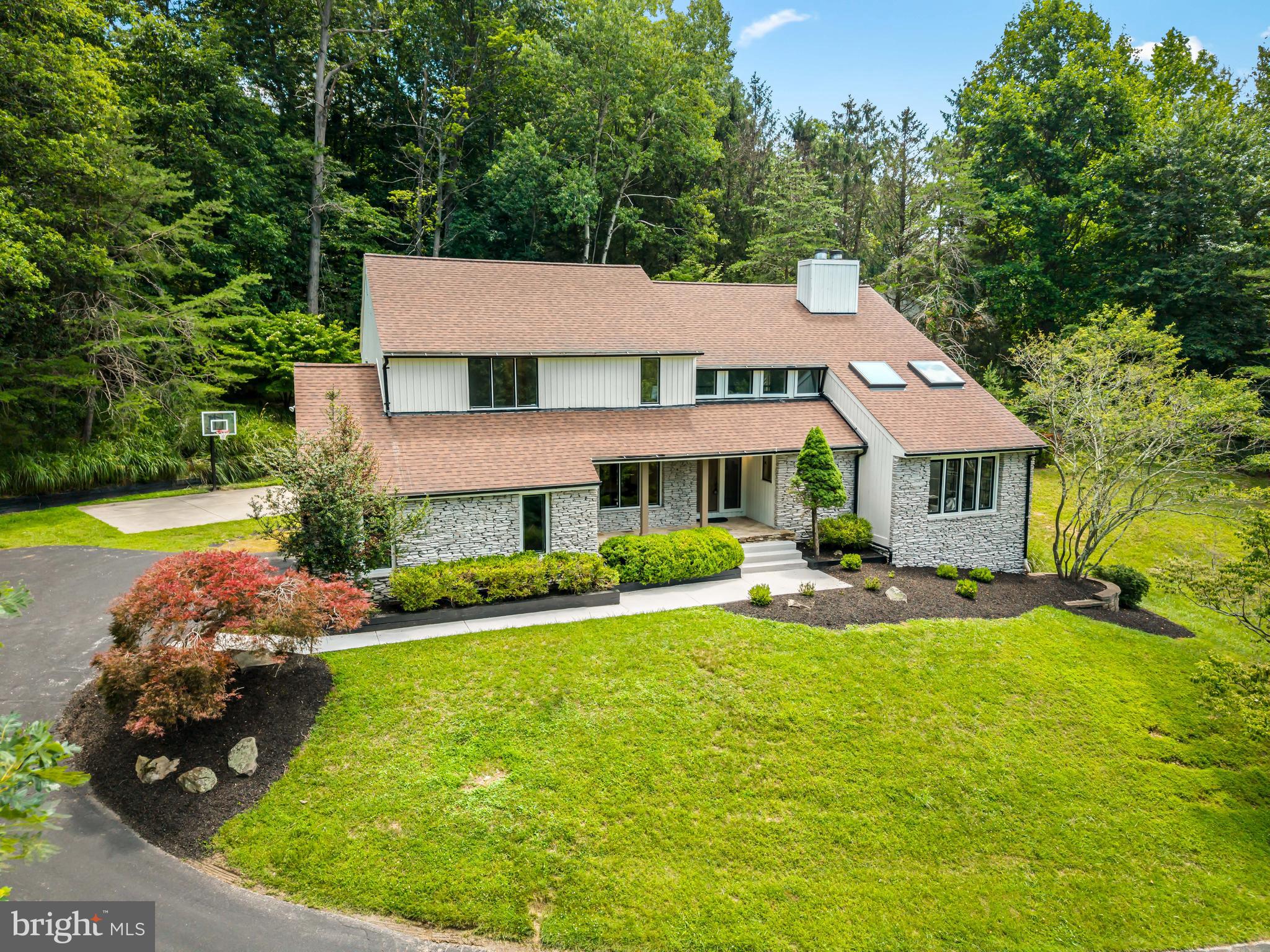 Welcome to 2318 Shaded Brook Drive, where timeless architecture meets sophisticated modern living. 

Completely reimagined and meticulously renovated, this exceptional contemporary residence is privately sited on 1.04 beautifully landscaped acres in the highly sought-after Valley Heights community. Offering nearly 5,000 square feet of thoughtfully designed living space, every detail has been carefully curated to deliver both striking style and everyday comfort.

From the moment you arrive, the home's impressive stone and board-and-batten exterior, expansive black framed windows, and mature landscaping create unforgettable curb appeal while providing exceptional privacy. Inside, soaring ceilings, abundant natural light, and an open, flowing floor plan create an atmosphere that is both elegant and welcoming.

Designed with entertaining in mind, the heart of the home is the stunning gourmet kitchen featuring quartz countertops, an oversized center island, and premium appliances.  A dramatic double-sided fireplace serves as the focal point between the beautifully appointed living spaces, adding warmth and architectural character throughout the main level.  The luxurious primary suite offers a true retreat with a generous walk-in closet and a spa-inspired bath designed for relaxation. Upstairs, spacious secondary bedrooms provide comfort for family and guests alike.

The finished walkout lower level offers exceptional versatility with expansive recreation space, a fifth bedroom or private office, a full bath, and a dedicated fitness room, perfect for today's work-from-home lifestyle, multi-generational living, or extended guest accommodations.  Outdoor living is equally impressive, featuring a spacious maintenance free deck overlooking the private rear yard, a concrete sport court, and beautifully landscaped grounds that invite both relaxation and entertaining.

Extensive updates include a new roof and skylights, updated HVAC systems, designer lighting, and comprehensive renovations throughout, offering the confidence and convenience of truly turnkey living.
Perfectly positioned on a private homesite central to, dining, parks, and major commuter routes, this one-of-a-kind residence seamlessly blends architectural distinction, luxury finishes, and modern functionality. Rarely does a home of this caliber become available in Valley Heights.