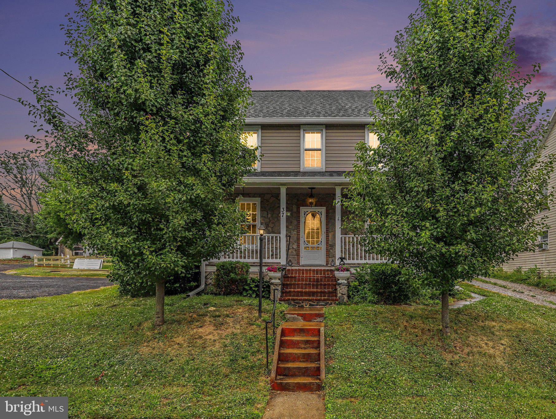 Nestled on just under 3/4 of an acre in the heart of Stewartstown, this beautifully renovated 4-bedroom, 2.5-bath colonial is packed with modern farmhouse charm and custom details throughout. Step onto the completely redone front porch featuring composite decking built to last, and into a stunning first floor with brand-new luxury vinyl plank flooring. The upgraded kitchen boasts granite countertops, stainless steel appliances, and a large center island; open to a spacious dining area and sitting room with coffered ceilings. Relax in the inviting living room anchored by a striking stone gas fireplace with reclaimed wood accent walls and original wood floors. A convenient first-floor laundry completes the main level. Upstairs, the private owner's suite features a vaulted ceiling with reclaimed wood, custom sliding barn doors, a walk-in closet, en-suite bath, and access to a private balcony; perfect for morning coffee. Three additional generously sized bedrooms and a full bath with double sinks round out the second floor, while the finished third-level attic with closet offers flexible space for a 5th bedroom, home office, or playroom. Outside, the expansive, fully fenced backyard is an entertainer's dream, complete with a pool deck, patio, large workshop, detached 2-car garage, and storage shed. All of this with public utilities and central A/C, just a short walk to grocery stores, dining, and Stewartstown Elementary School. Easy access to I-83 makes commuting a breeze. This is truly a must-see!