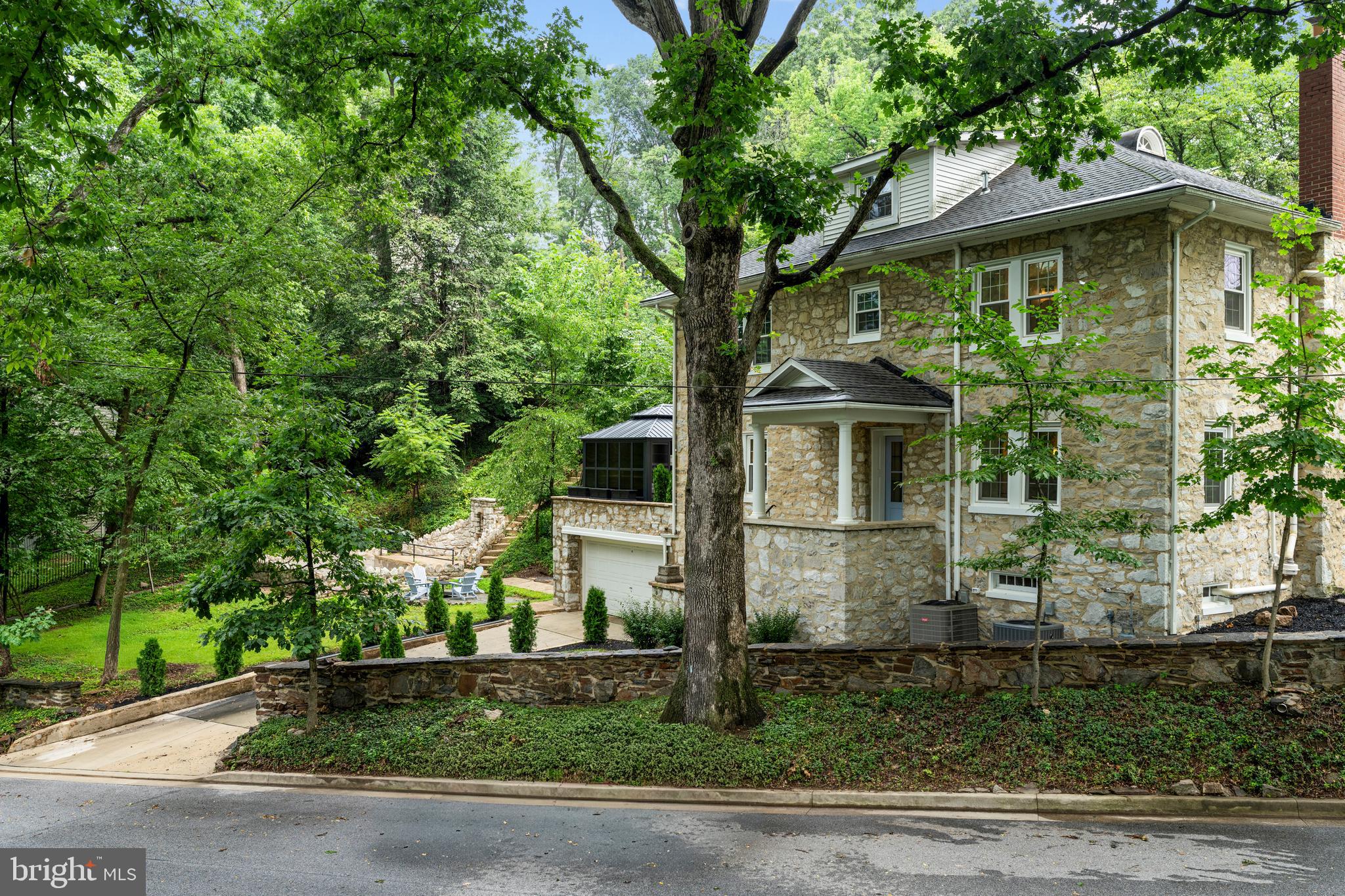 Welcome to 814 Edgewood Road, a beautifully renovated 4-bedroom, 3.5-bath classic stone colonial home in the heart of Towson Estates. Thoughtfully redesigned for modern living, this exceptional property blends timeless character with luxury finishes and outstanding functionality.

The main level features a welcoming living room that opens to a stunning kitchen and dining space designed for entertaining. The chef's kitchen offers quartz countertops, premium appliances, designer finishes, and a charming breakfast booth filled with natural light. Just beyond, an English conservatory-inspired sunroom serves as a beautiful extension of the living space, creating the perfect setting for relaxing, entertaining, and enjoying views of the surrounding grounds.

Adding exceptional convenience to daily life, the main level also features a spacious pantry, dedicated laundry area, and a well-appointed half bath.

The second level includes three bedrooms and two full baths, including a spacious primary suite with abundant closet space and a luxurious ensuite bath featuring a soaking tub, oversized shower, and double vanity. Two additional generously sized bedrooms share a beautifully updated hall bath. The third floor offers a private bedroom, full bath, and flexible bonus space ideal for guests, a home office, or additional living area.

Outdoor living is equally impressive, featuring mature landscaping, a charming patio, and a private deck just off the sunroom, creating multiple spaces for entertaining and relaxation. A unique historic pond feature—once believed to have served as a communal swimming pool and gathering place for neighborhood residents—adds character, history, and distinction to the property's remarkable setting.

The lower level provides abundant storage space and additional flexibility for future use. Completing the home is a rare attached two-car garage, offering convenience and practicality that is seldom found in historic neighborhoods.

Located on a coveted lot at the entrance to one of Towson's most sought-after neighborhoods, this exceptional home is a rare opportunity to own a thoughtfully updated property that perfectly balances historic charm with modern luxury.